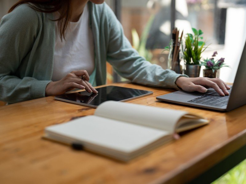 Writing notes while using a tablet.
