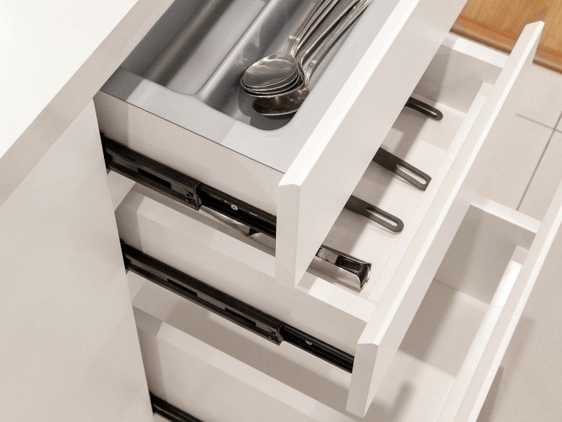 Organizing utensils neatly in drawers.