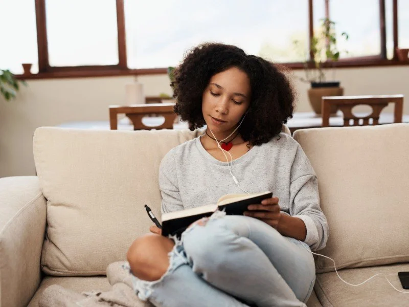 Relaxing with book, headphones, tranquility.