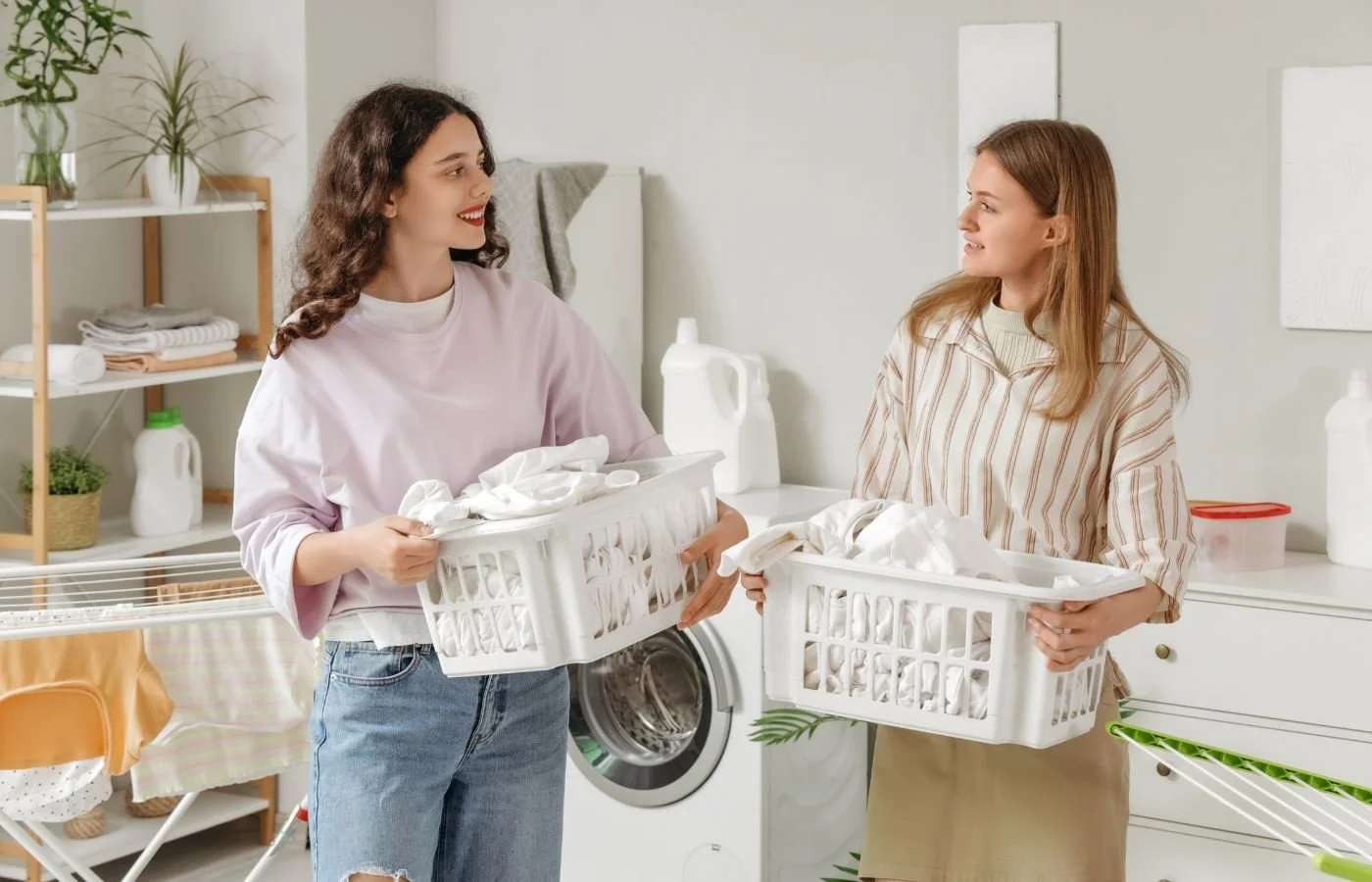 Women holding laundry baskets smiling