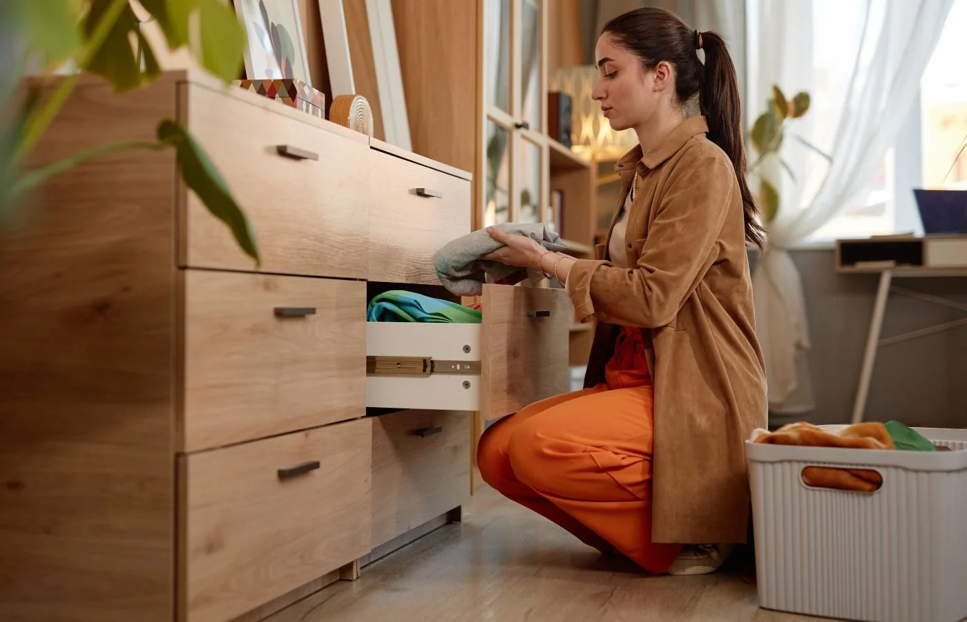Efficient Housekeeping - Woman organizing clothes in drawer