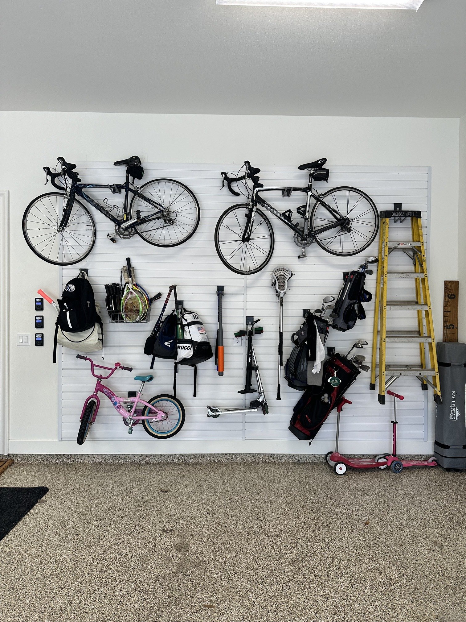 the uncluttered life garage organization with bicycles hung on wall