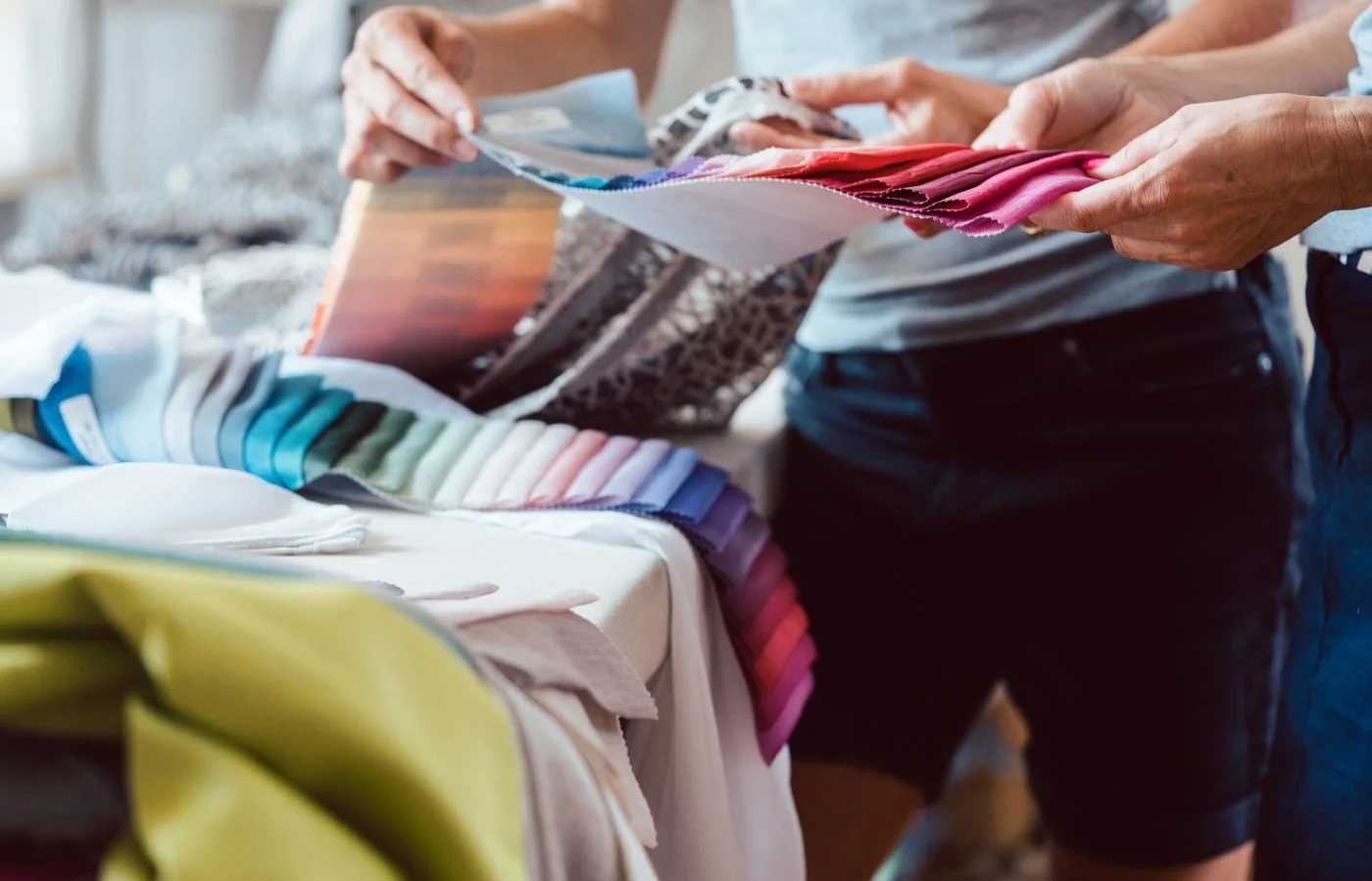 How to love your home Hands browsing colorful fabric swatches.