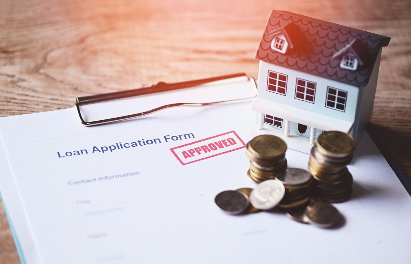 Here’s a short 5-word alt text for this image:  **Loan approval with coins, house**