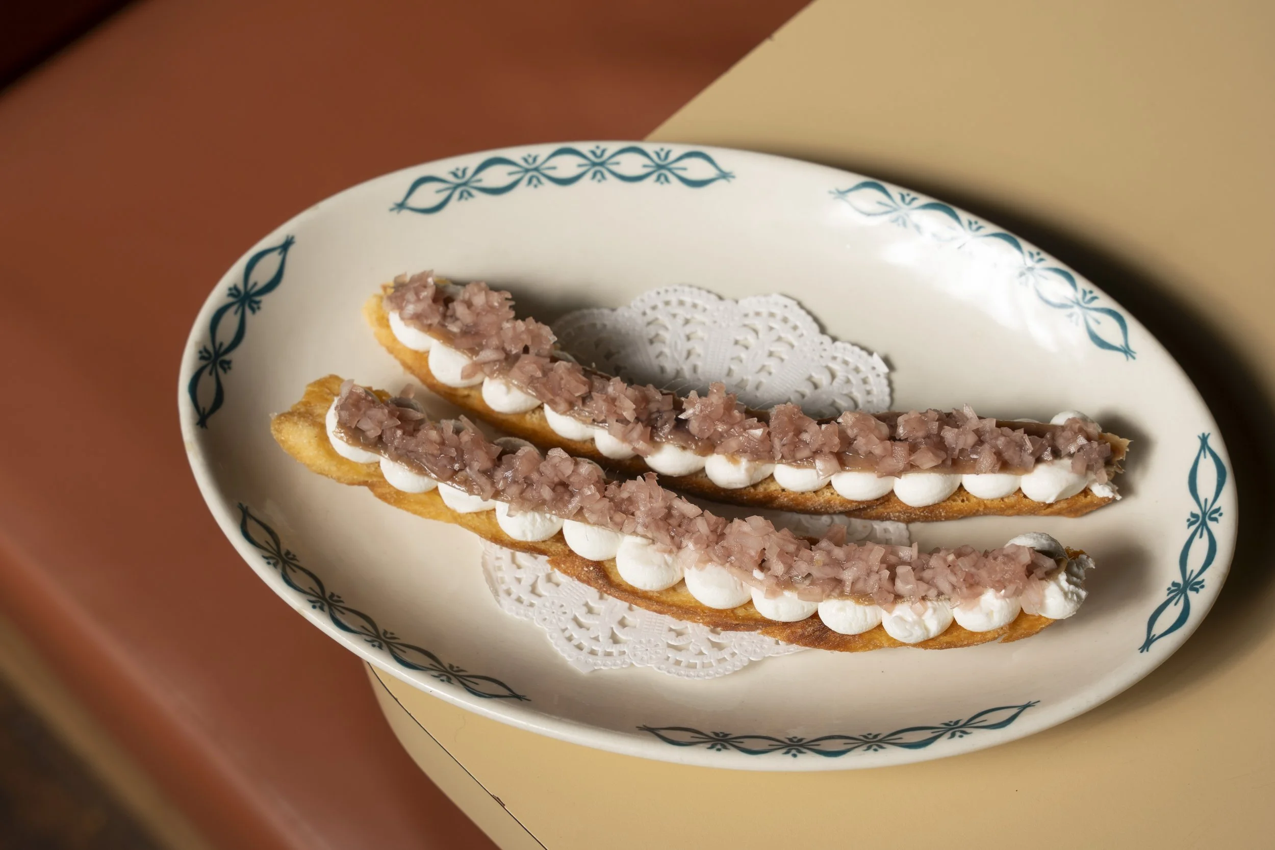 Two pieces of bread on a decorative plate, topped with white cream and a pinkish topping. Gold Coast | Byron Bay Food Photography by Joey Bailey