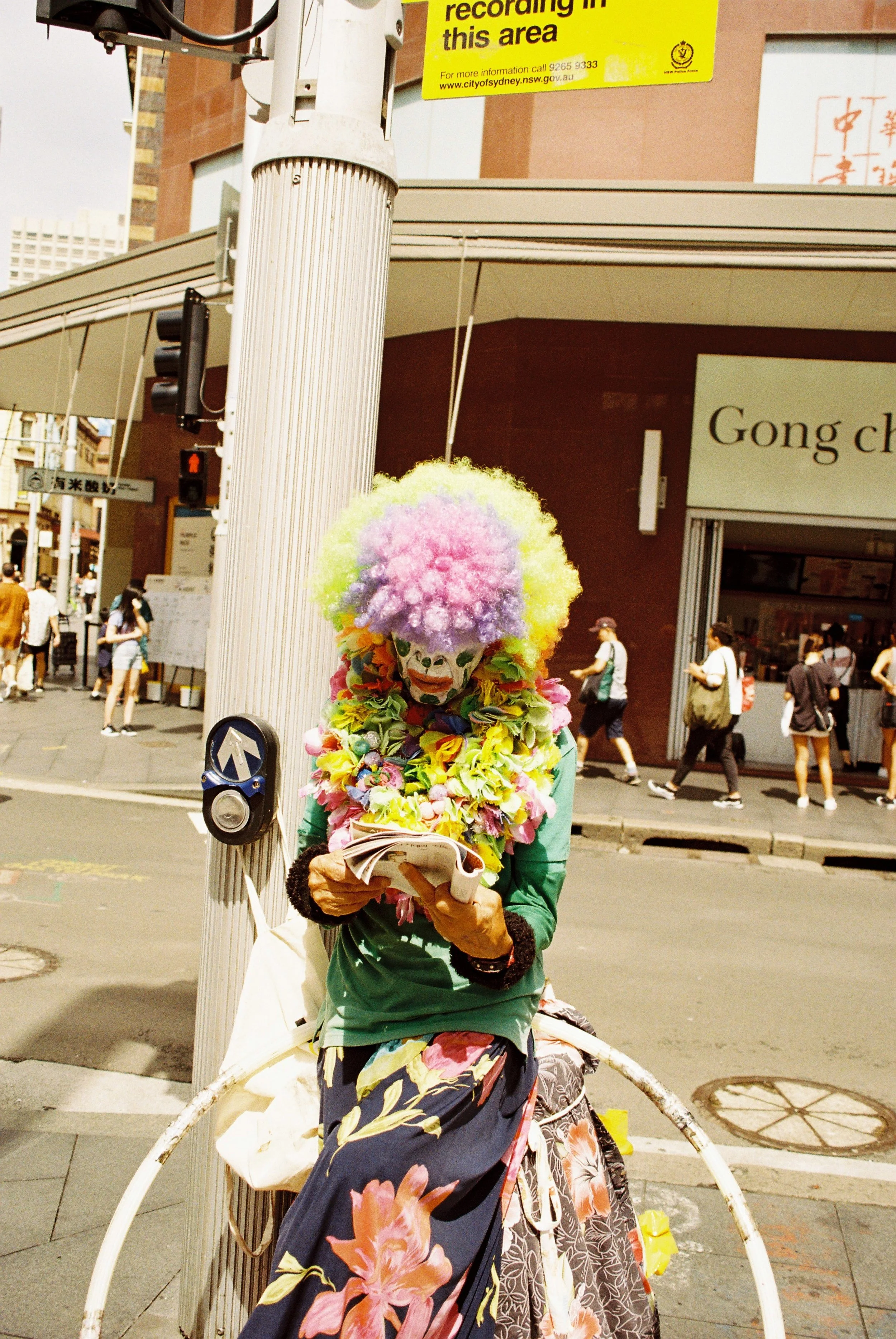 35mm street photography clown reading paper