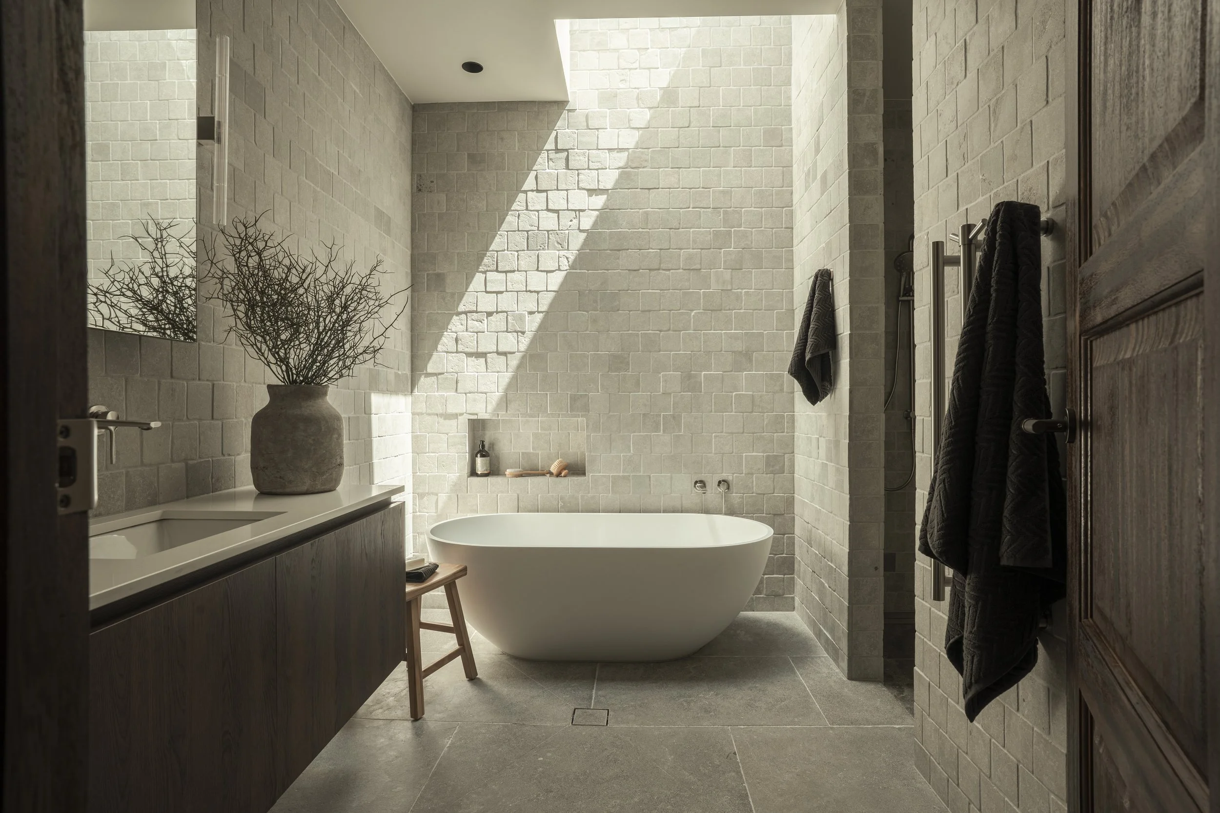 Modern bathroom with bathtub, potted plant, and towel rack. Currumbin Architecture Photography Joey Bailey