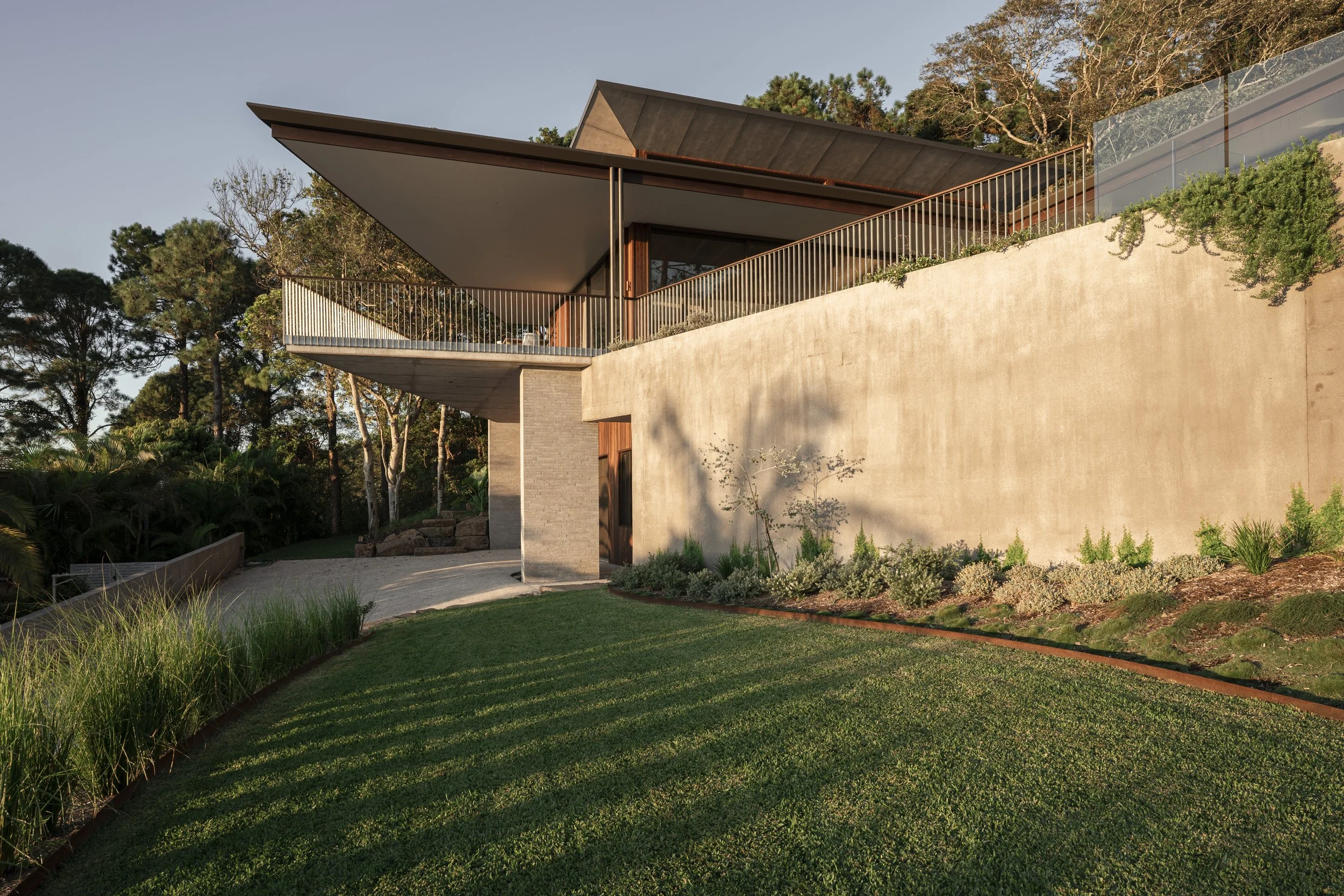 Modern house with a large balcony, surrounded by greenery, during sunset. Cape House, Suffolk Park – architectural photography