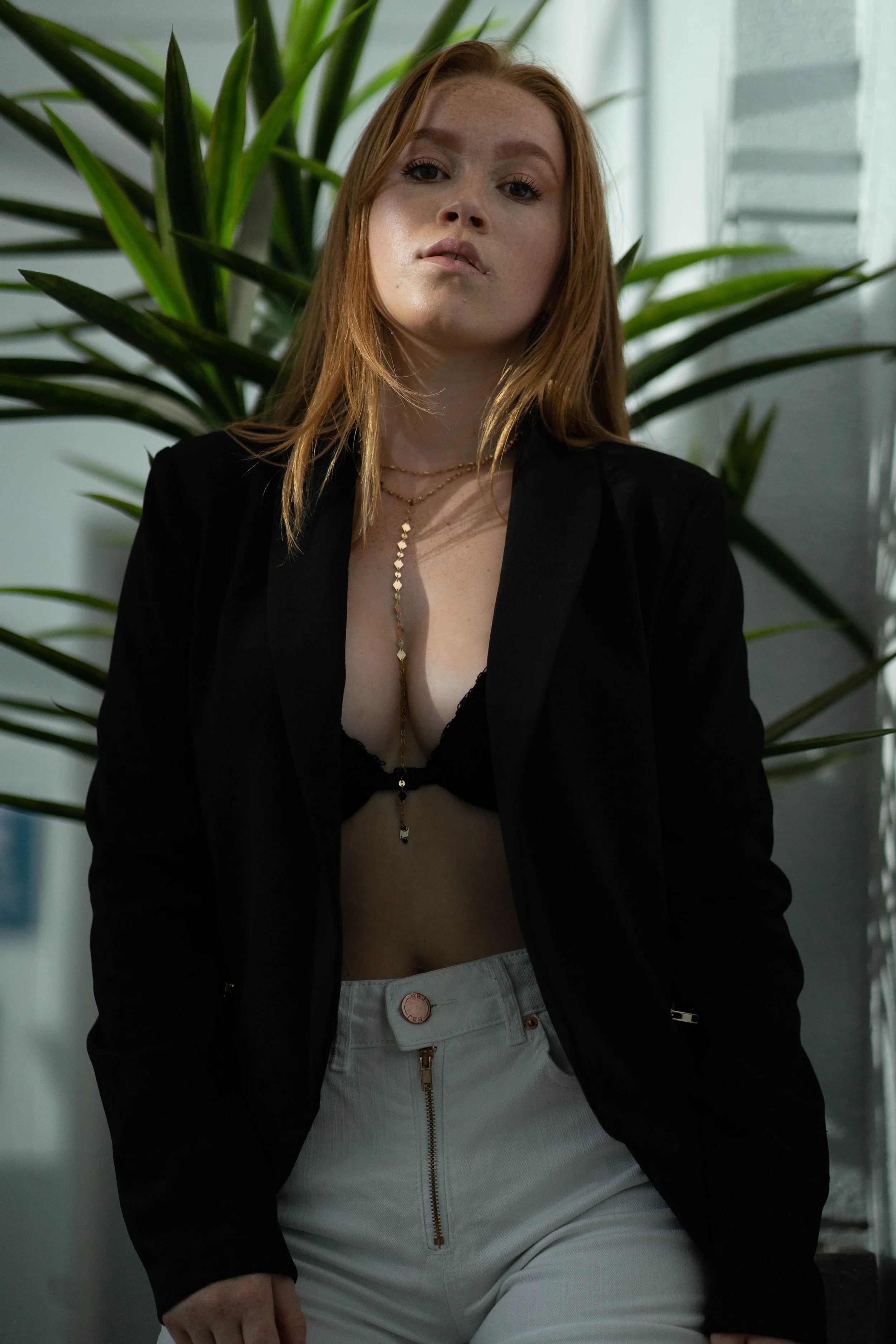 Group of ten diverse young people in black and stylish casual clothing, posing in an industrial setting with concrete walls.