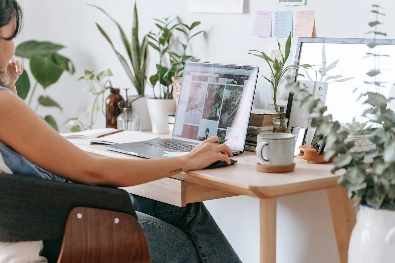 Ottawa small business owner, woman sitting at her computer surrounded by plants working on her privacy policy for her website.