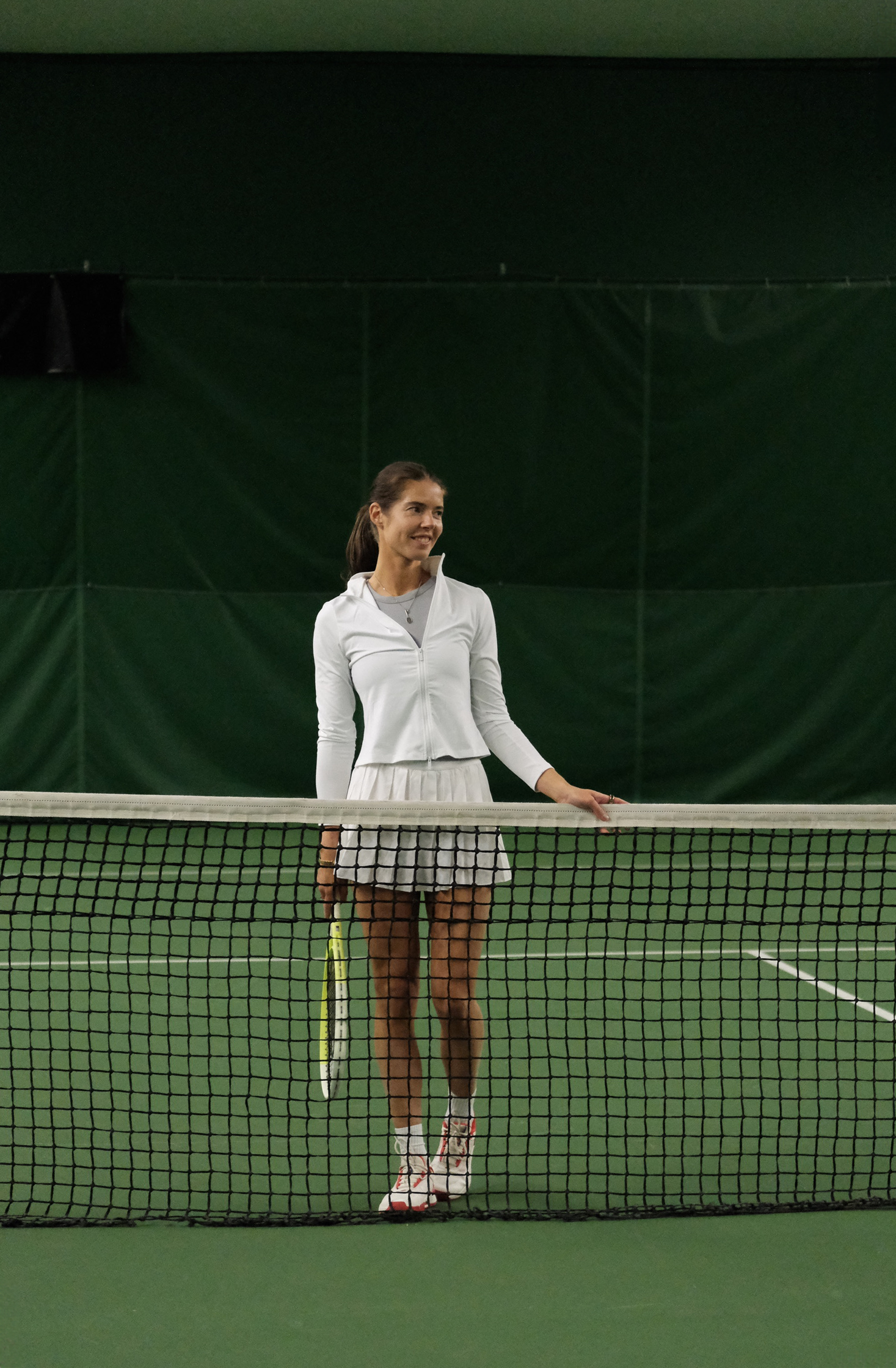 Ria seisoo verkon luona maila kädessä ja hymyilee.