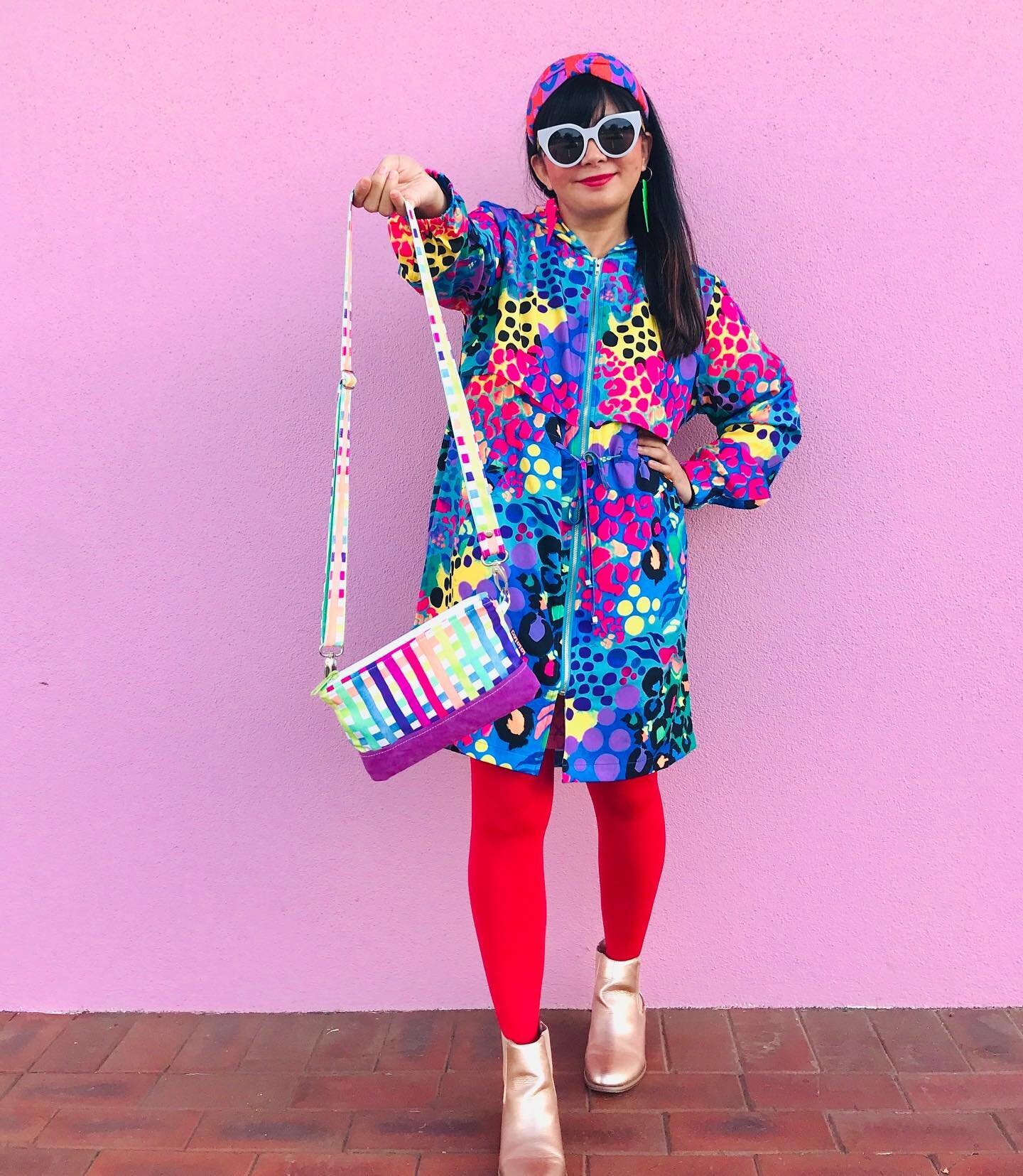 Taking a moment to appreciate this look by rainbow in human form @keanujess and her @lalalea.makes bag in my neon rainbow print! 🌈💕

[ID: Jess stands in front of a pink wall holding a colourful bag! She&rsquo;s wearing bright red tights and a coulo