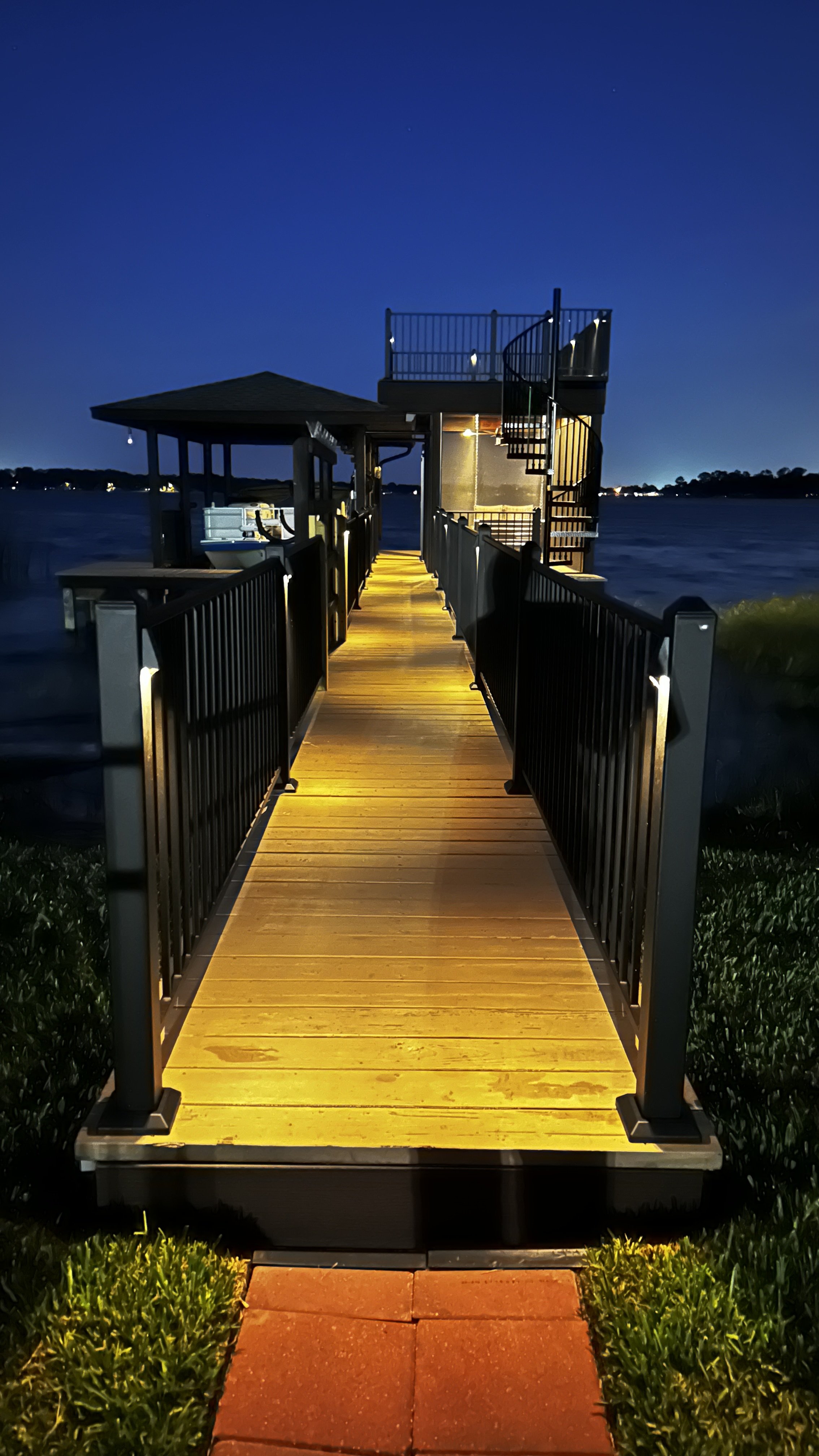 Moody Deck on Dock: Trex Decking, Spiral Staircase, & Lighting | Fortress Railing | ScreenEZE Screens