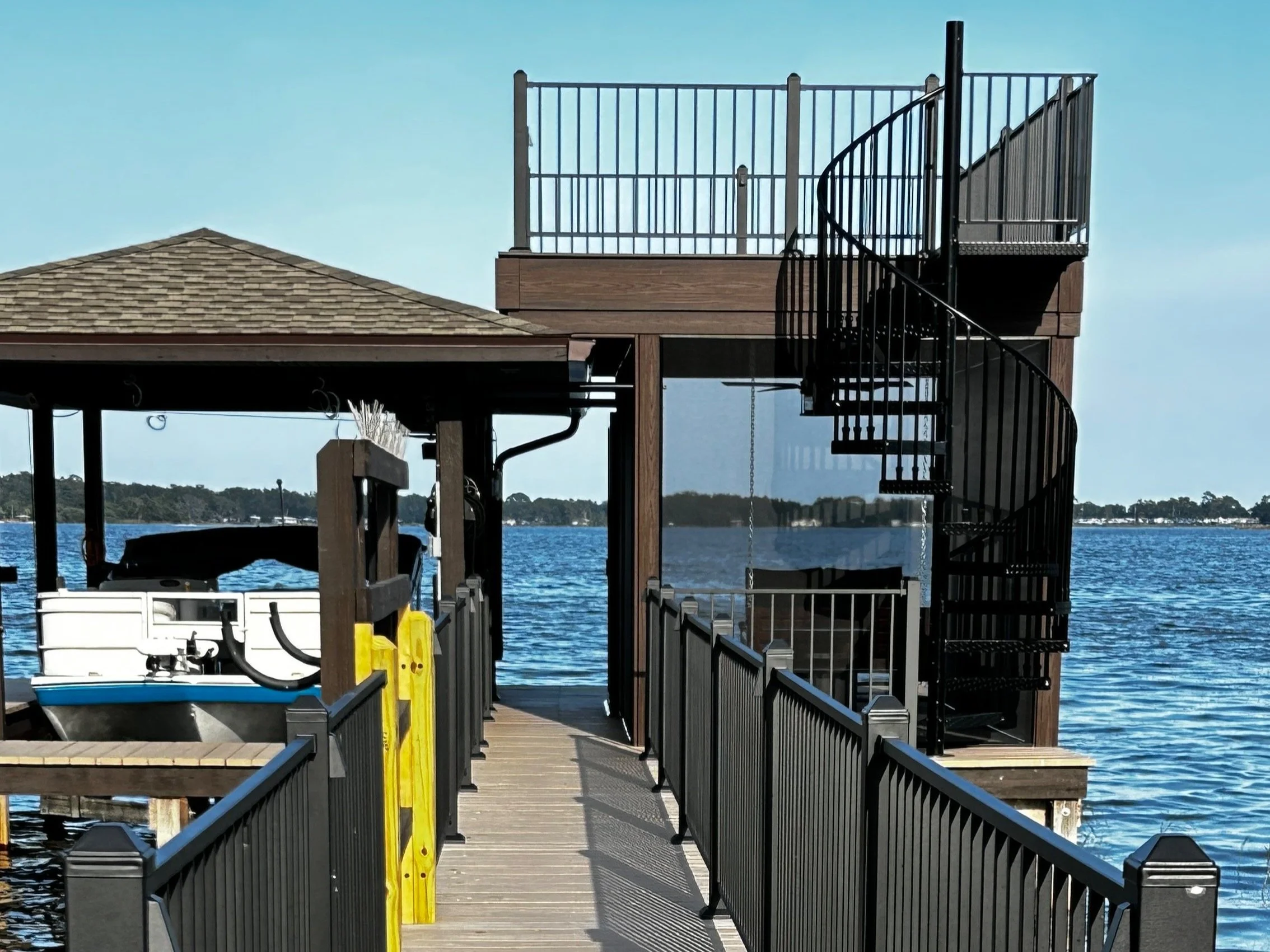Raised deck constructed on lakefront property. Custom deck includes waterproofing system, low voltage lighting, can lights with ceiling fan, composite decking and aluminum railing and beautiful spiral staircase. Below deck is an enclosed ScreenEZE sc