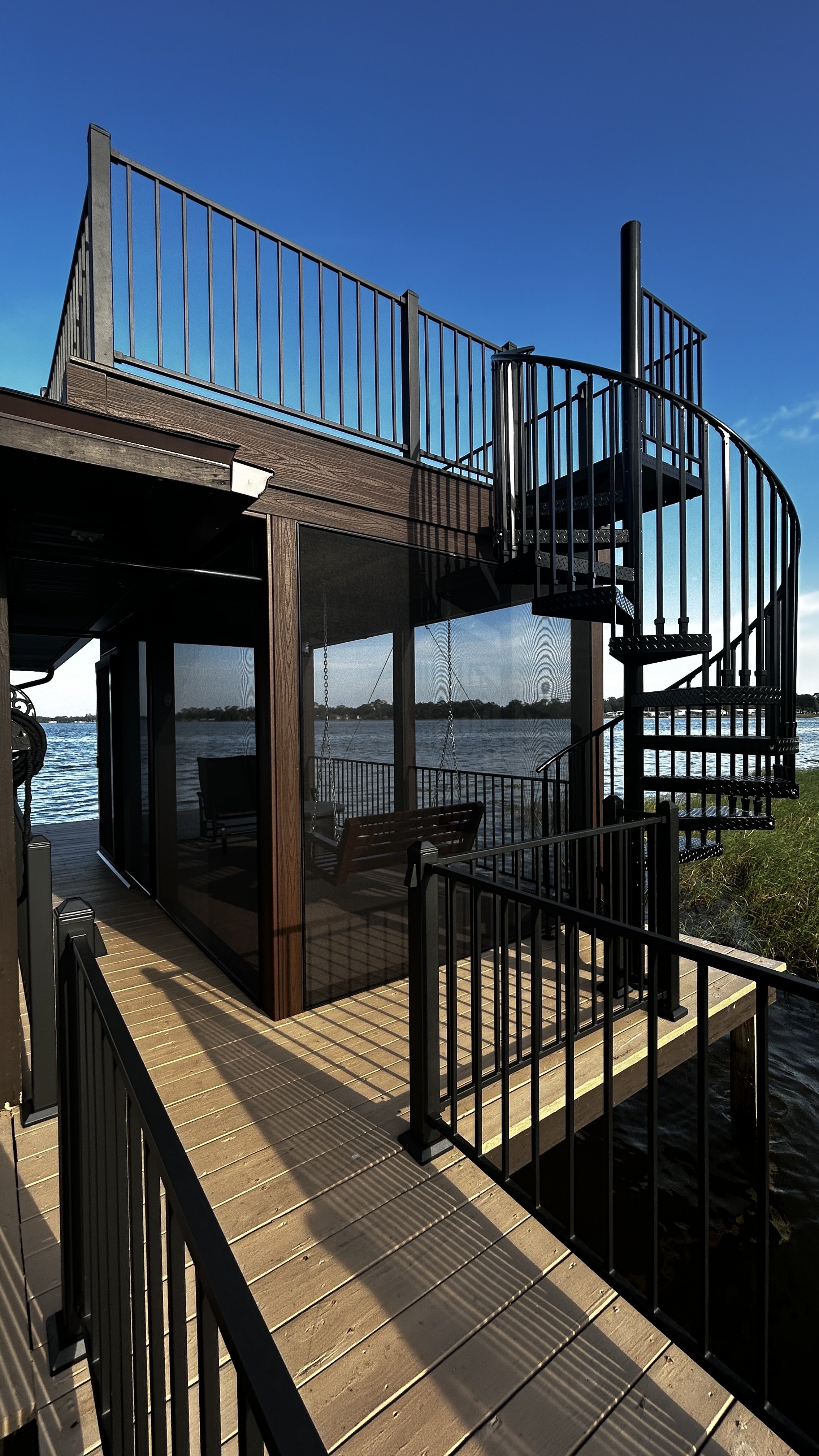 Moody Deck on Dock: Trex Decking, Spiral Staircase, & Lighting | Fortress Railing | ScreenEZE Screens