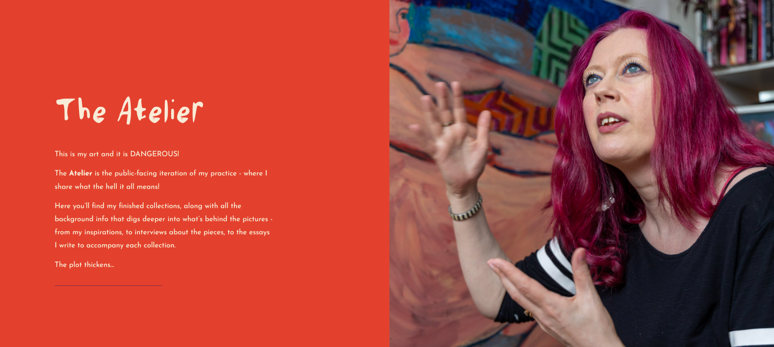 A woman with bright pink hair, wearing a black top with white stripes on the sleeves, gesturing with her hands, in front of a colorful abstract painting and a bookshelf.