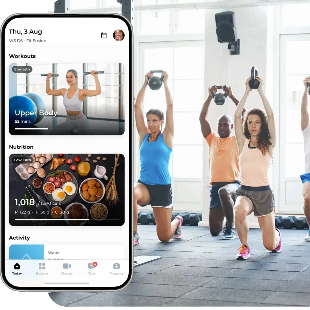 Group fitness class in a gym with participants holding kettlebells overhead, and a smartphone displaying a workout app showing strength, nutrition, and activity information.