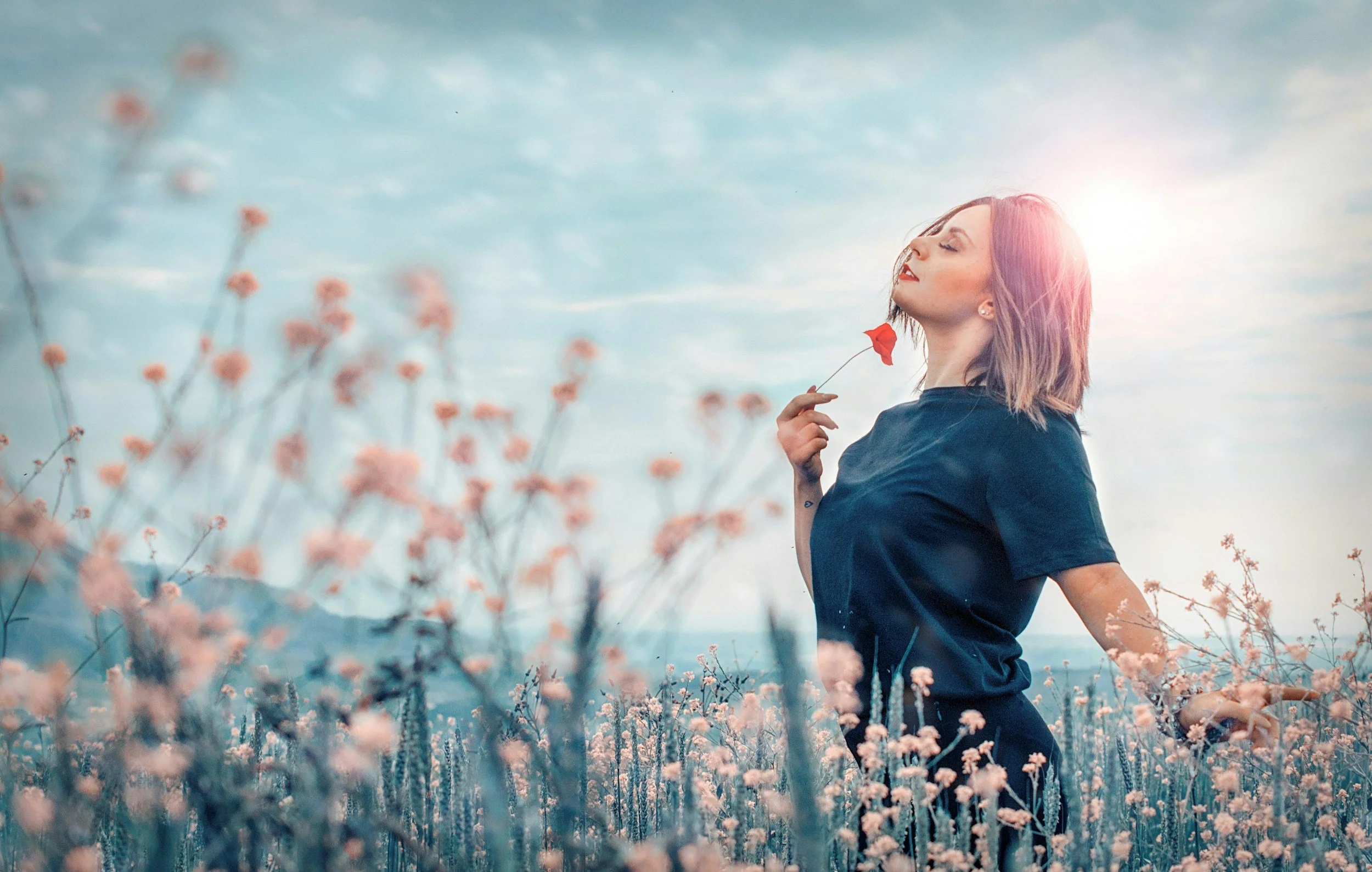 Woman in a field of flowers looking relaxed and relieved, representing hormone balance, reduced inflammation, and improved well-being through functional medicine