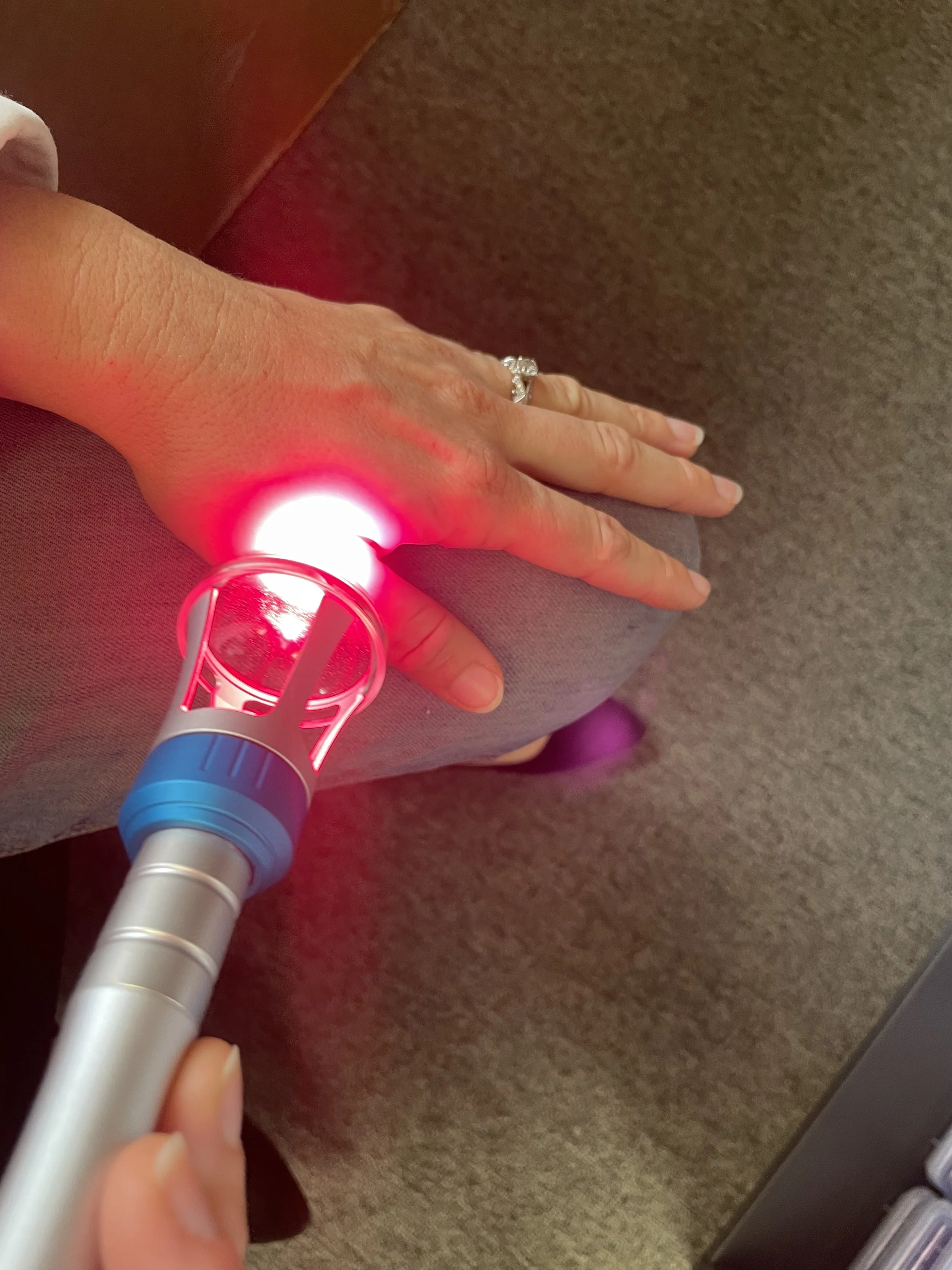 Cold laser therapy being applied to a patient's hand at Premier IFM serving Fullerton and Orange County CA