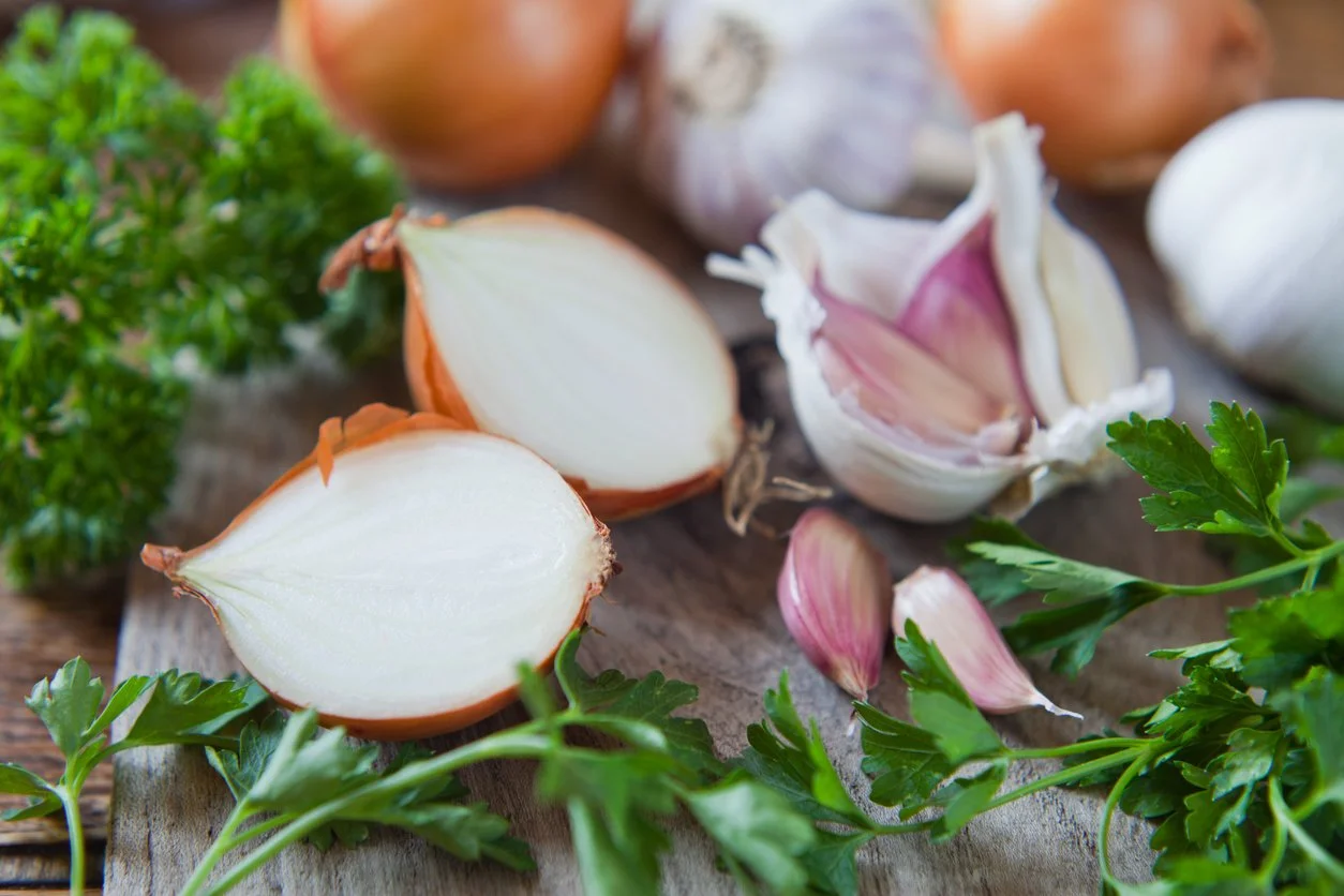 Garlic and onion high FODMAP foods that worsen SIBO symptoms like bloating, gas, and digestive discomfort