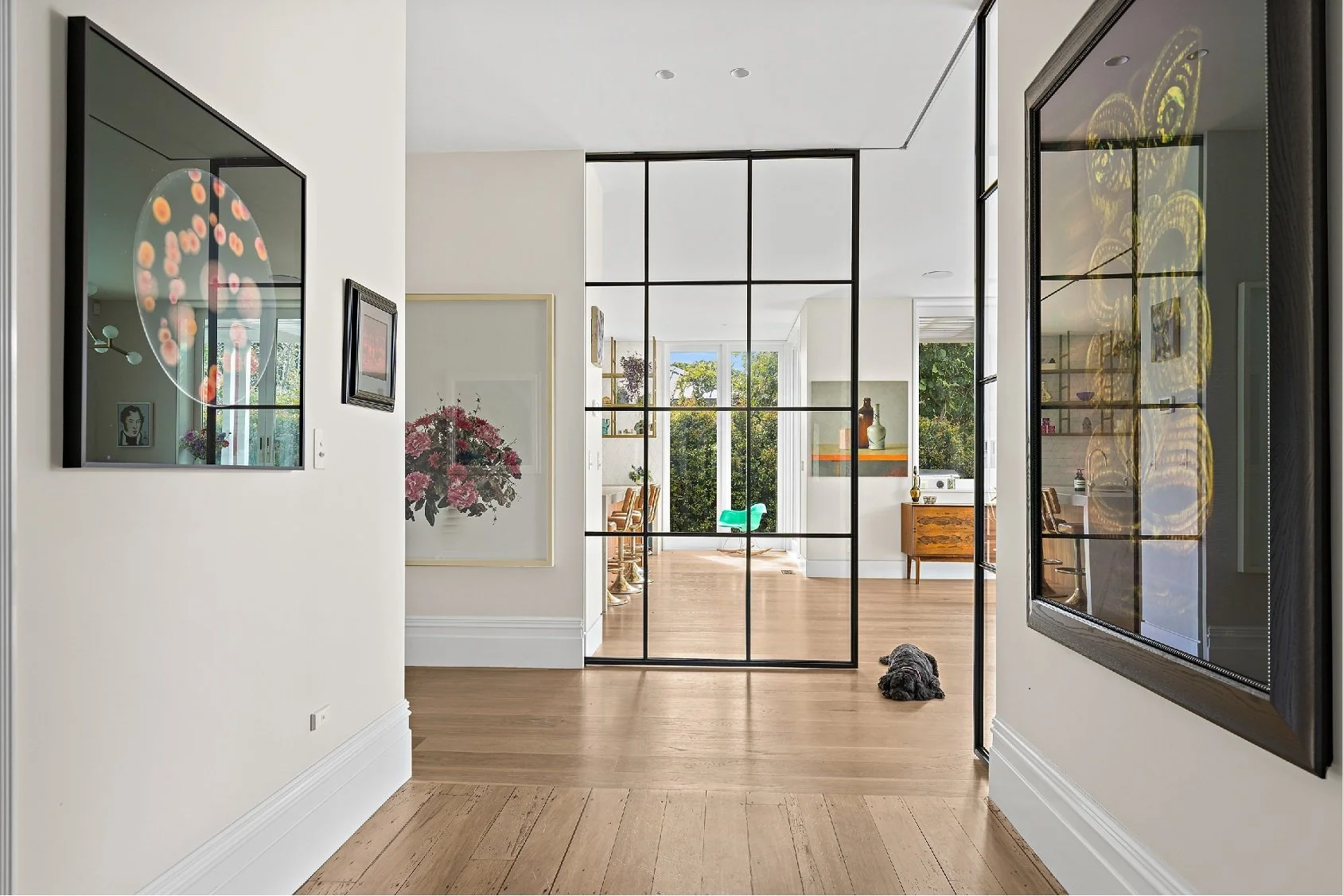 a stylish hallway in a residential home leading to Crittall-style doors opening into a large kitchen area