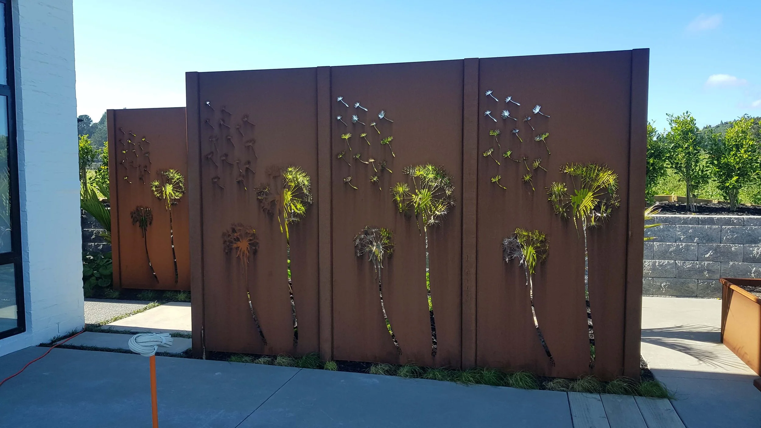 corten steel outdoor screens with dandelion artwork
