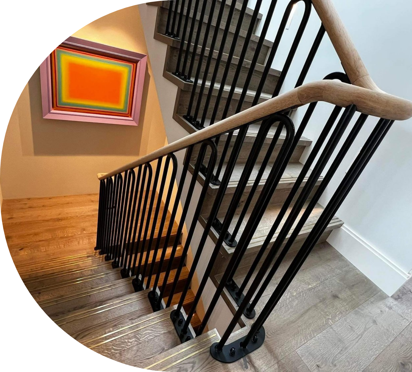 looking down at an internal stairway with steel balustrades with modern art on the wall