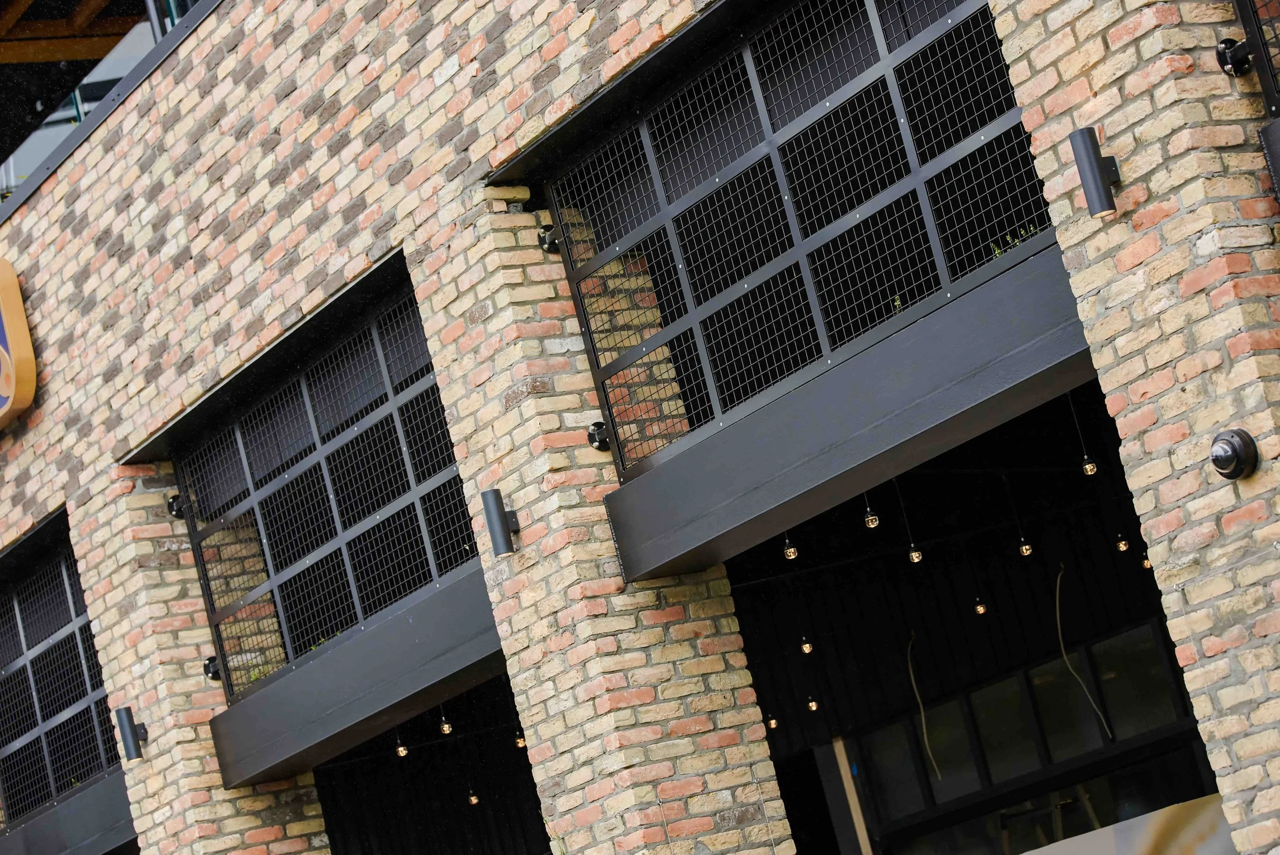 Outdoor Commercial Steelwork - an entranceway with steel frames on a brick building