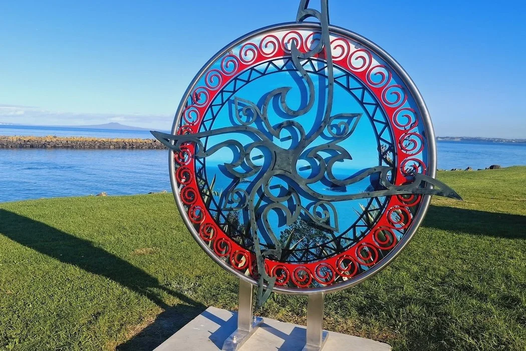 Steel sculpture coloured red and black overlooking the ocean