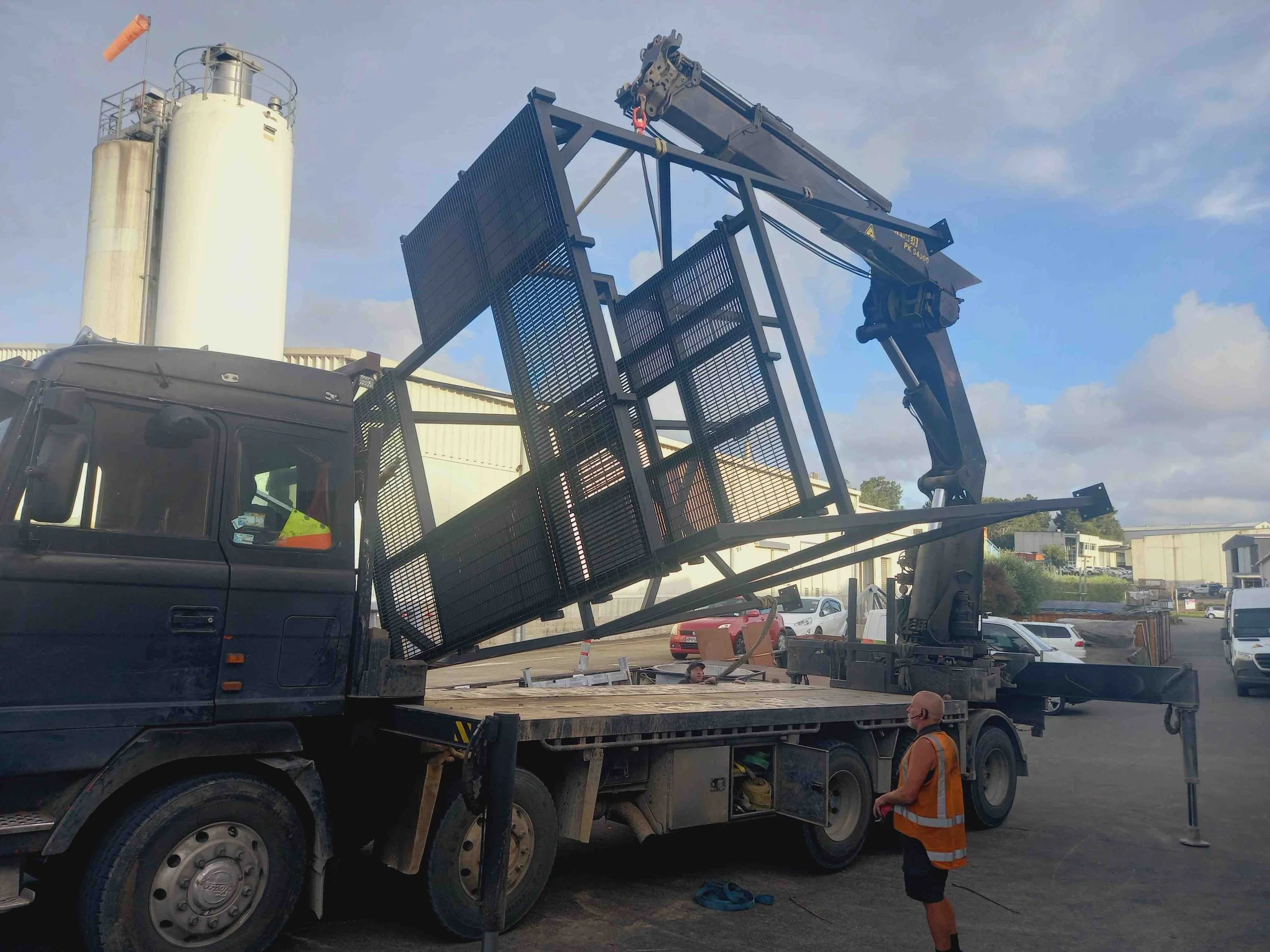 industrial steel frames being lifted by crane onto a truck in Auckland