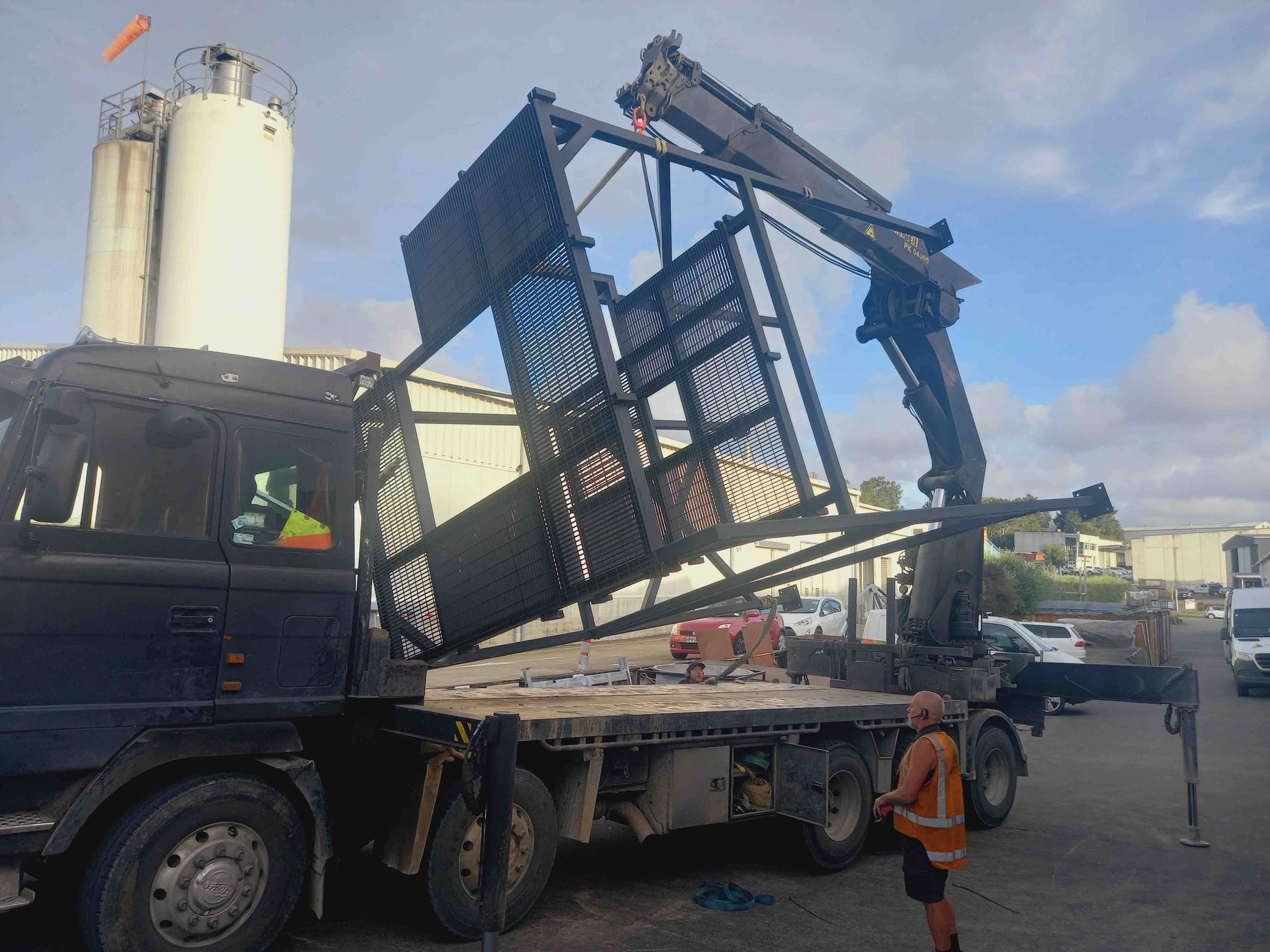 Industrial steel frames being lifted by a crane onto back of a truck for delivery in Auckland