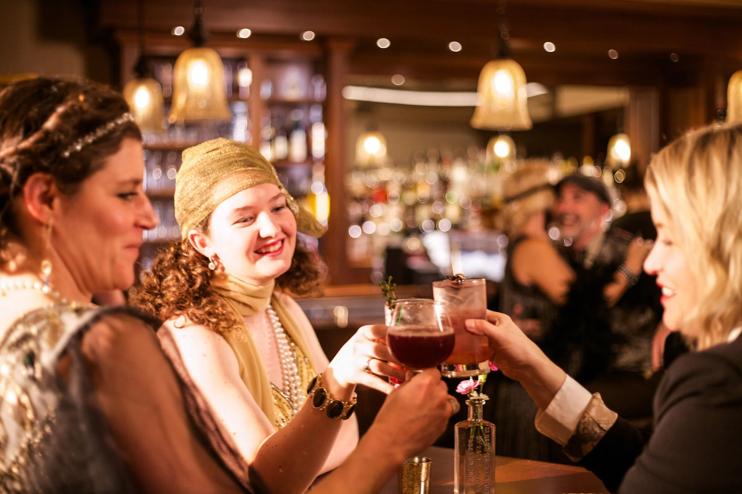 1920's photoshoot of Alli and coworkers clinking glasses