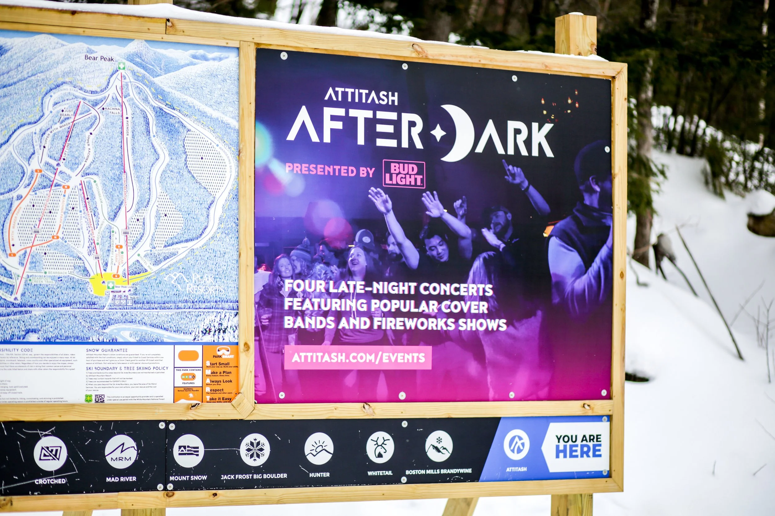 Trail Map signage at Attitash Mountain ski resort featuring Attitash After Dark concert series advertisement poster