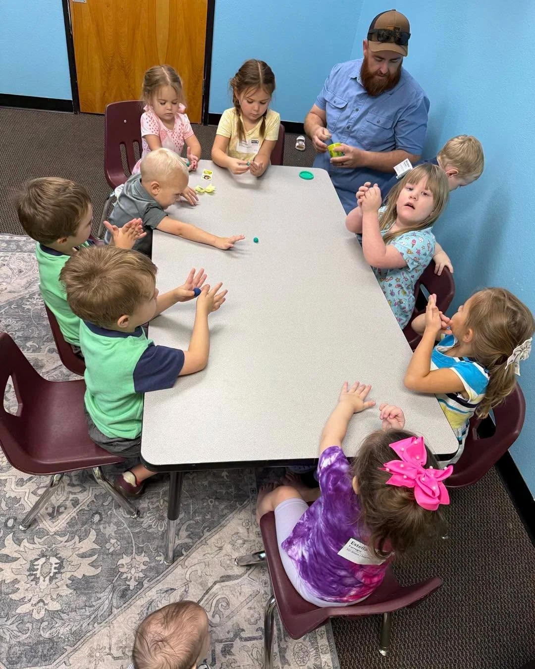 Children and a ministry volunteer learning together at Restoring Hope.