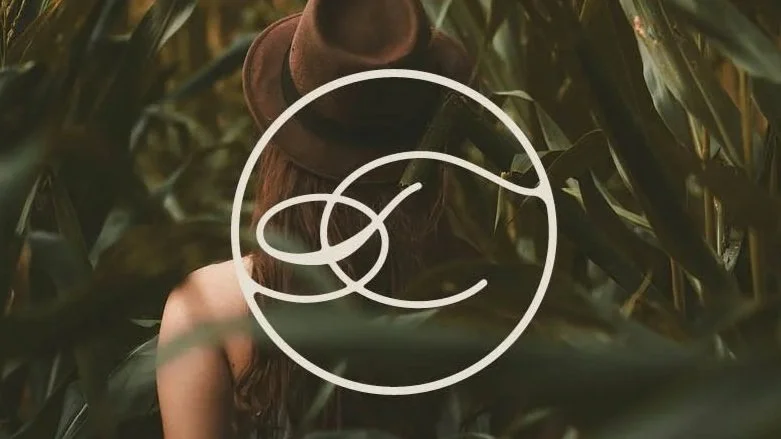 Stylized logo with the word 'TEND' in the center, surrounded by a circular design with an abstract floral or leaf motif.