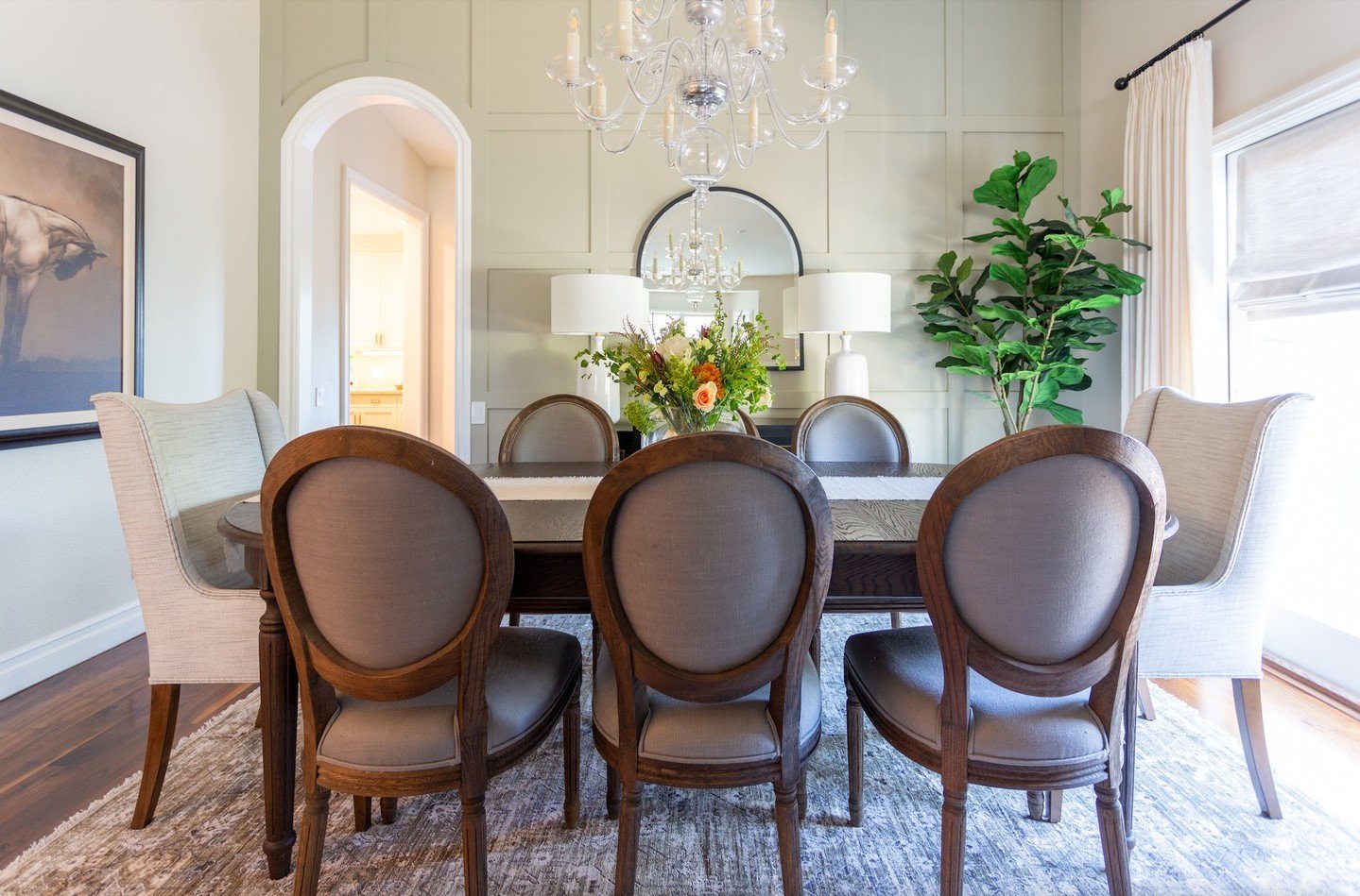 From bland to beautiful! ✨✨ This family dining room went from drab to fab with a complete makeover. We kept the existing table and chandelier but added custom host chairs and a stunning wall treatment to infuse warmth and character. Now, it's the per