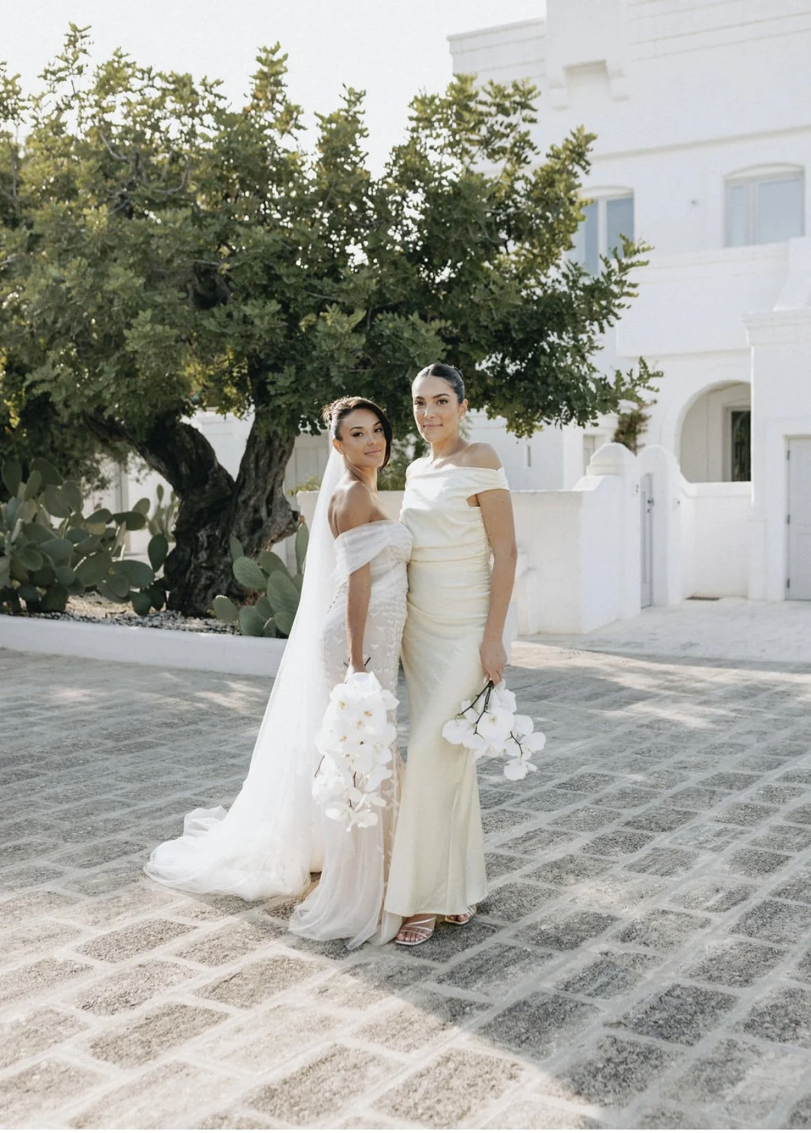 Bride wearing refined destination bridal makeup alongside a loved one at Masseria Borgo Ritella in Puglia, Italy.