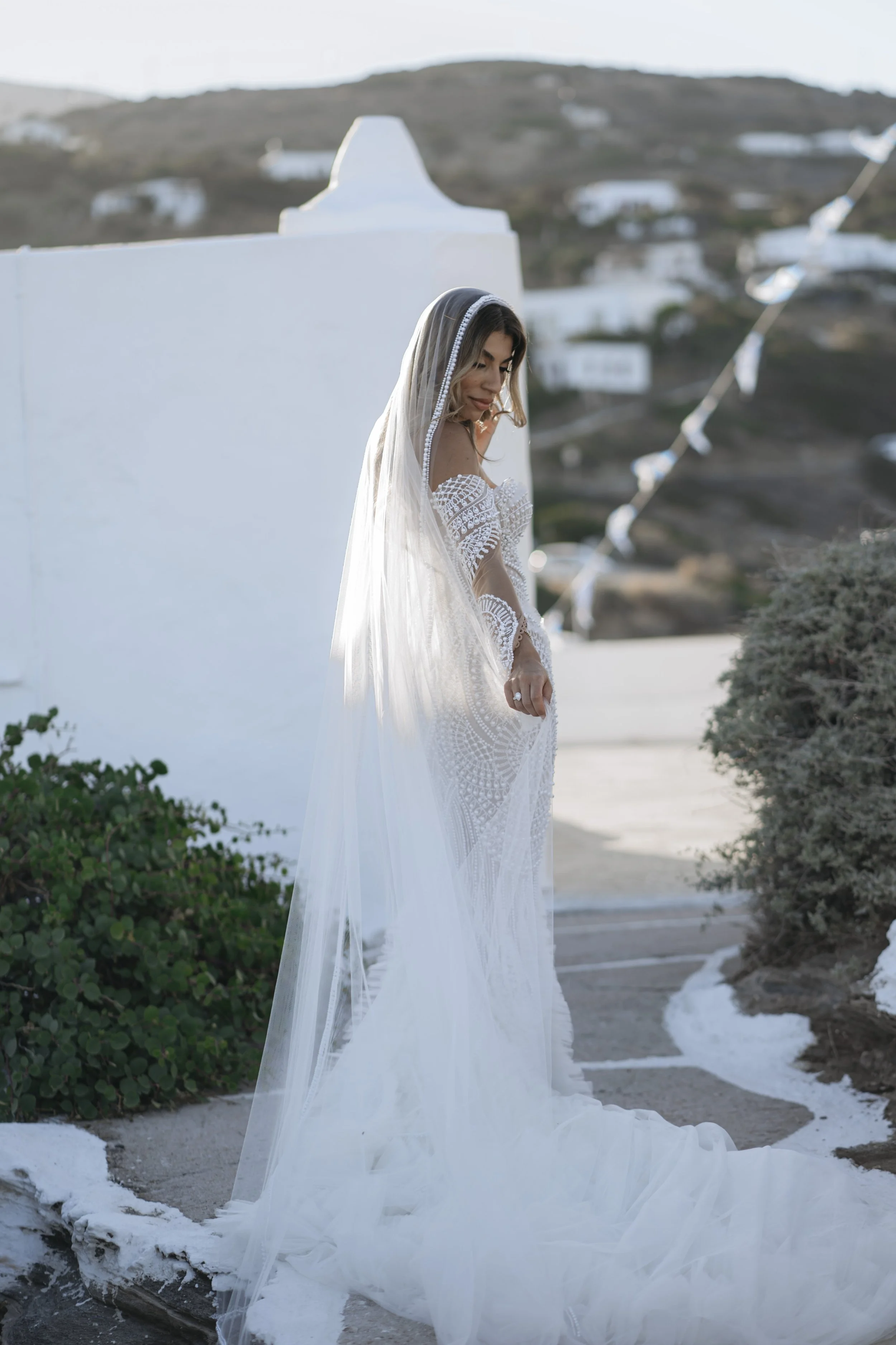Bride in a Leah Da Gloria gown outside Chrisopigi Monastery in Sifnos, Greece, wearing soft bridal makeup.