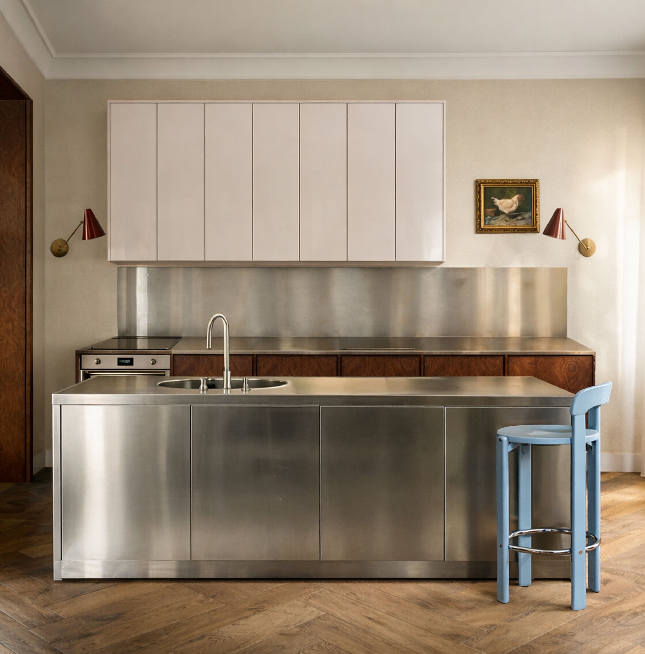 Modern minimalist kitchen with stainless steel island, soft natural light from the right, white cabinets, walnut wood details, and herringbone wood flooring