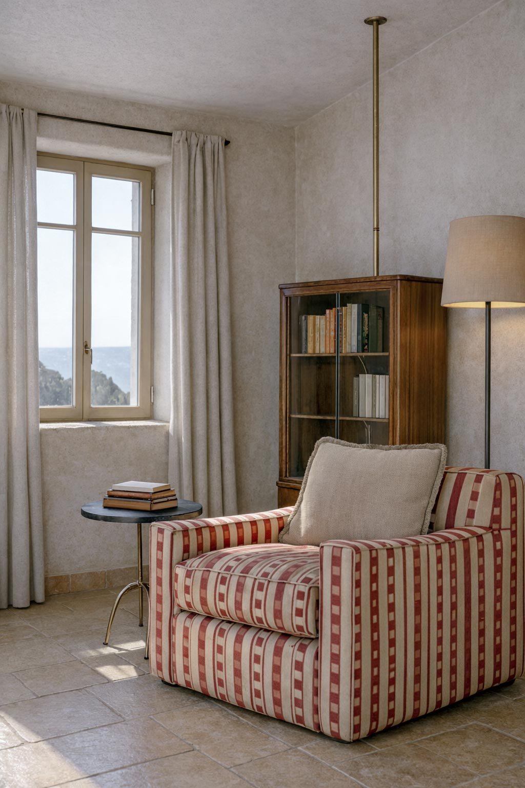 reading area with comfortable armchair with window in the background with seaside view