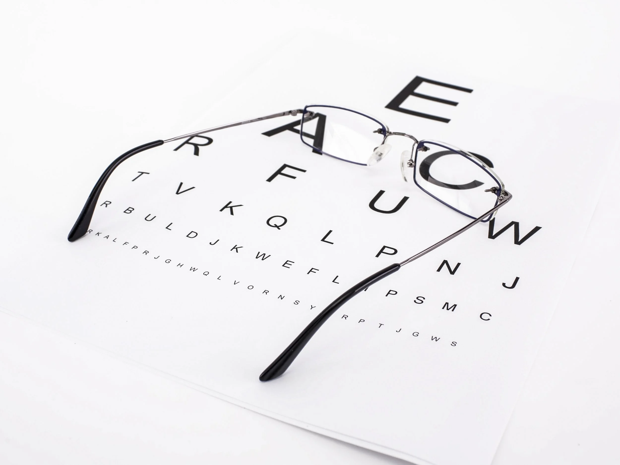 A Snellen Test Chart with a pair of glasses on top.