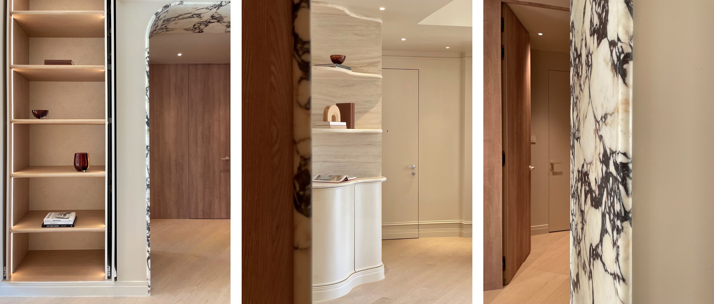 Interior view of a modern, minimalistic living space with built-in shelves, wooden doors, marble accents, and neutral-colored walls and flooring.