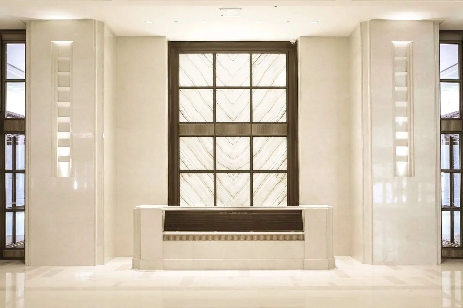 Modern interior with a large central window, marble walls, and built-in lighting accents.