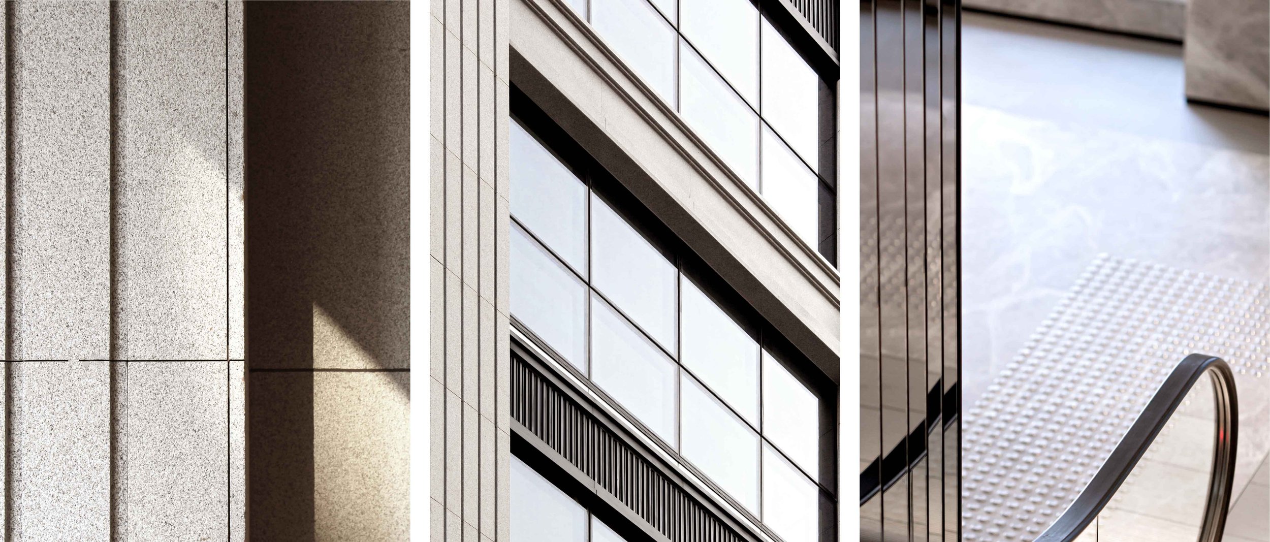 Close-up of modern building exterior with large glass windows, concrete panels, and a metal handrail at a staircase.