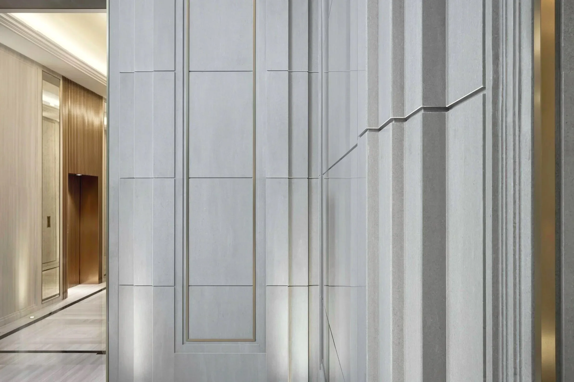 Modern building interior with metallic wall panels and an elevator door on the left.