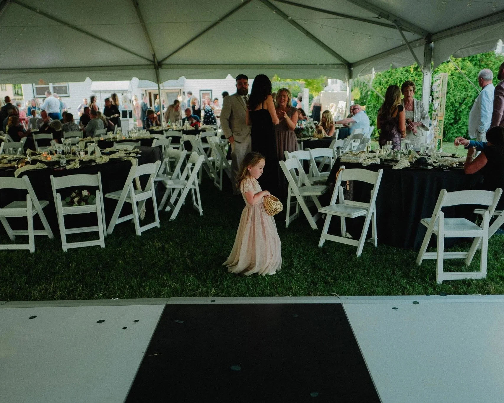 Little girl in a dress at a tented outdoor wedding reception