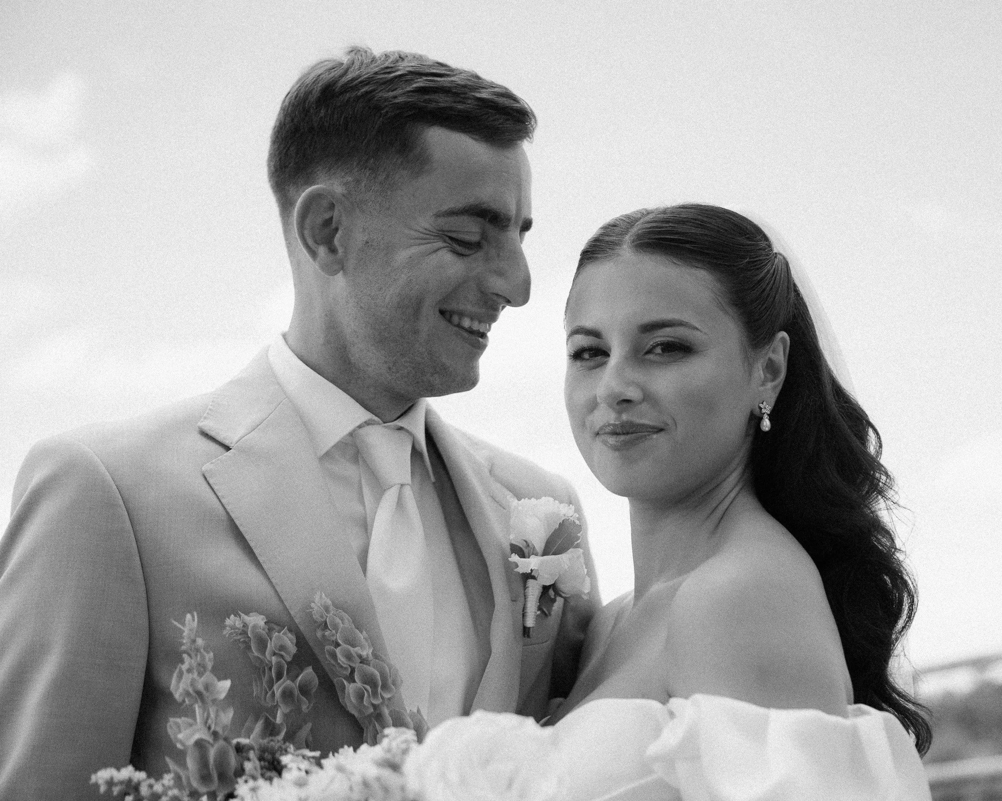 Black and white portrait of a smiling bride and groom close together