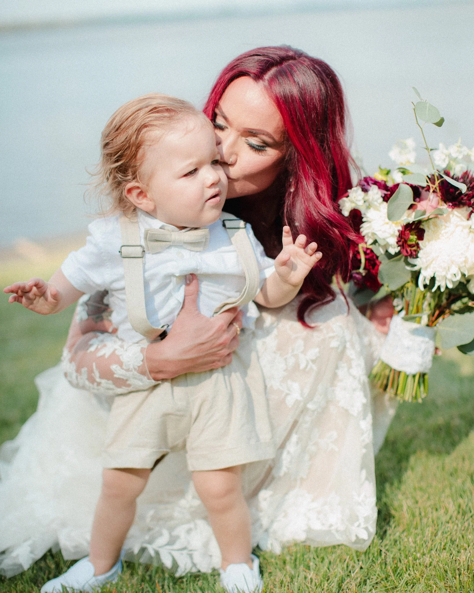 Bride with red hair kissing a toddler ring bearer, New Jersey wedding