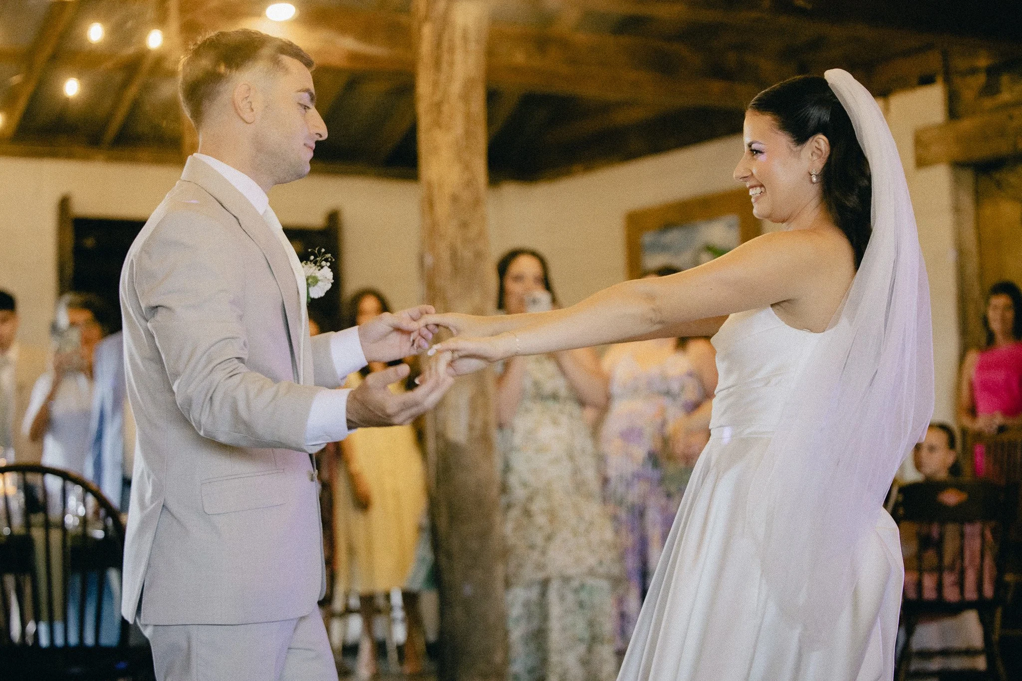 Bride and groom sharing their first dance at a rustic wedding reception