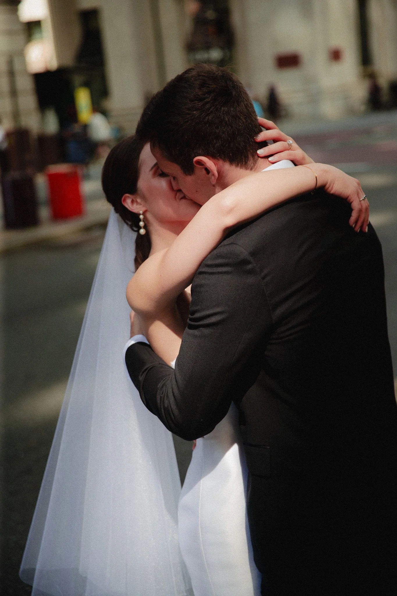 Bride and groom embracing in a kiss outside the church after the ceremony